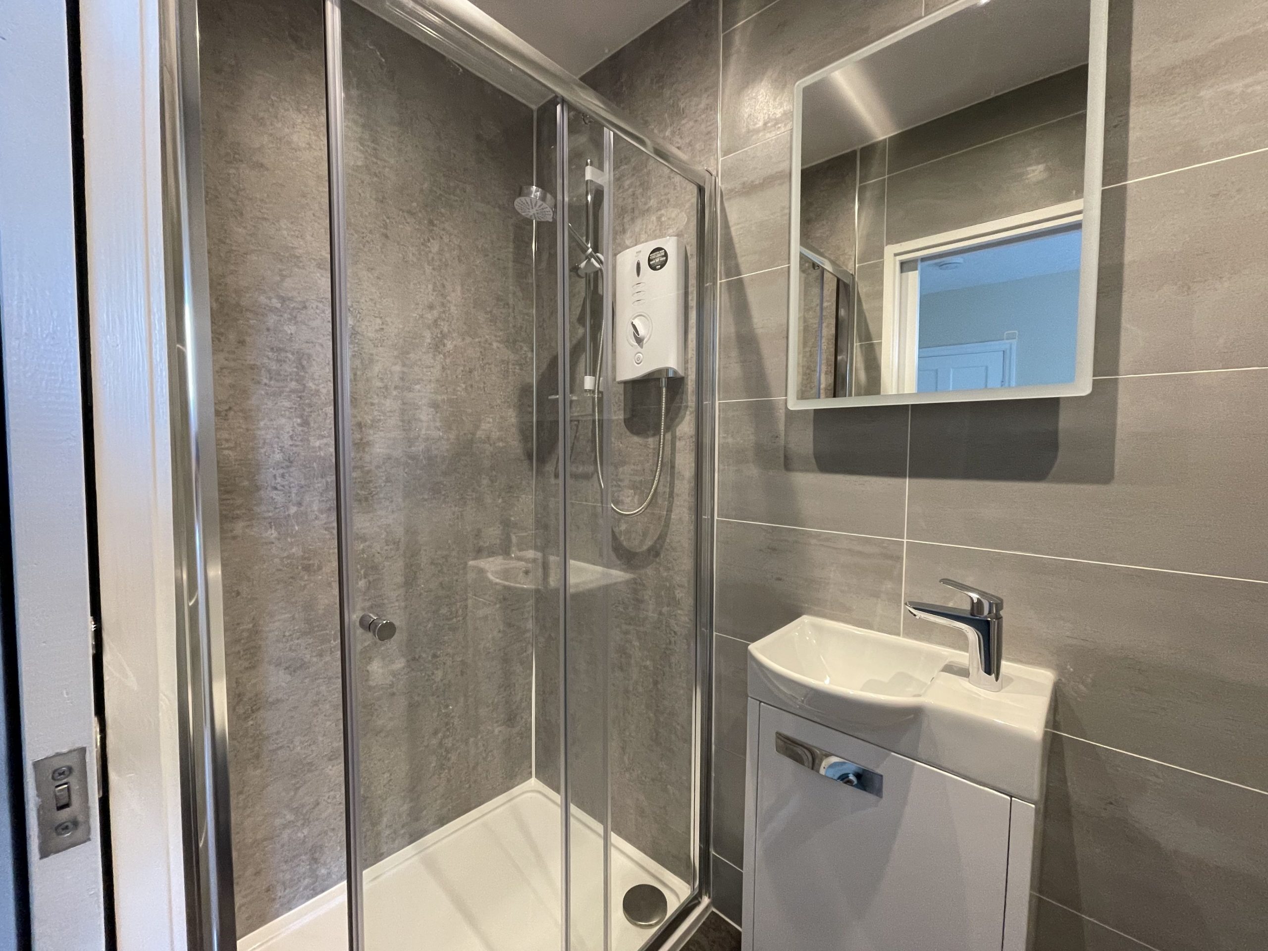 The shower room is modern and comprises walk in shower, hand basin, WC and heated towel rail