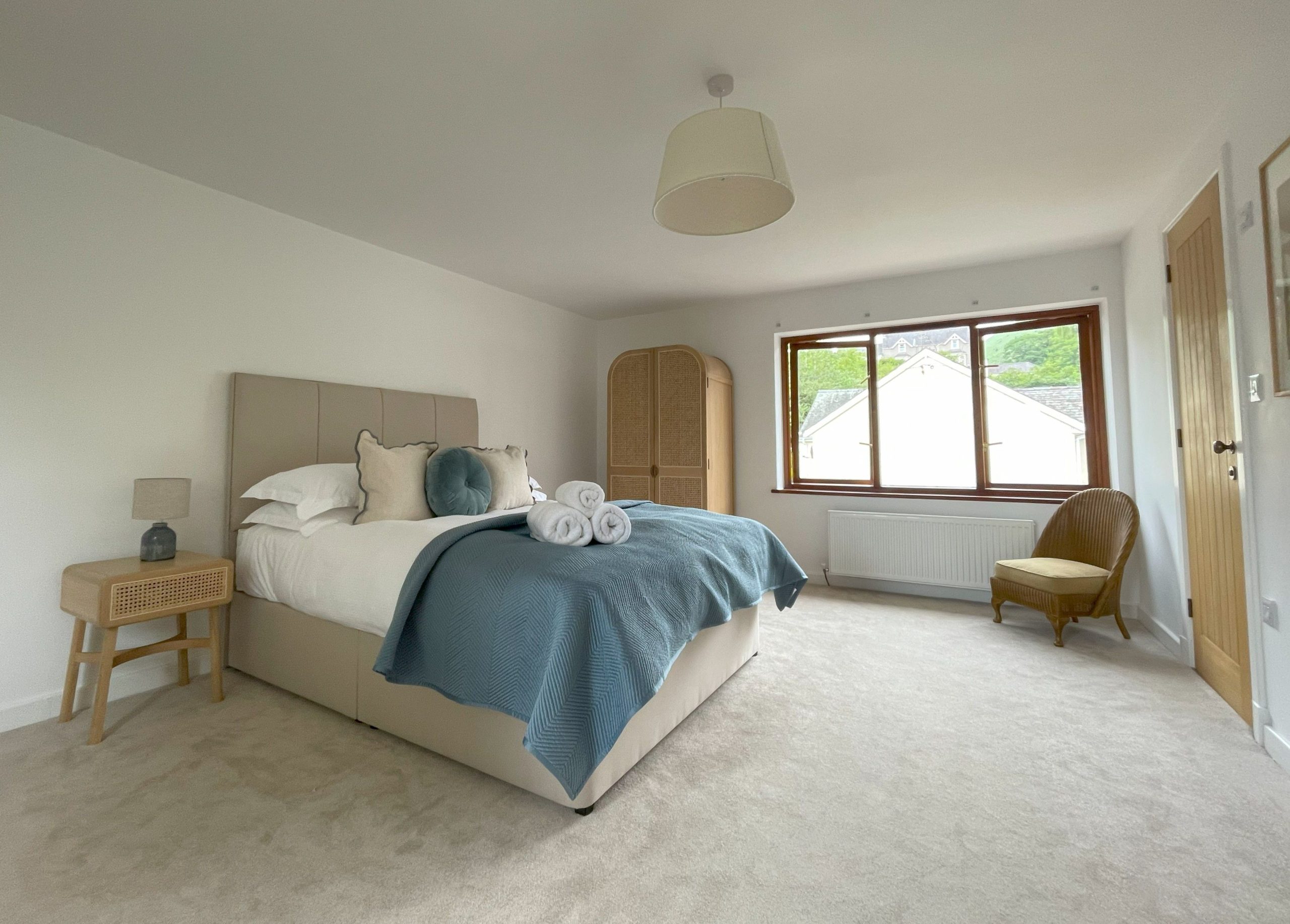 A spacious and light master bedroom with king sized bed