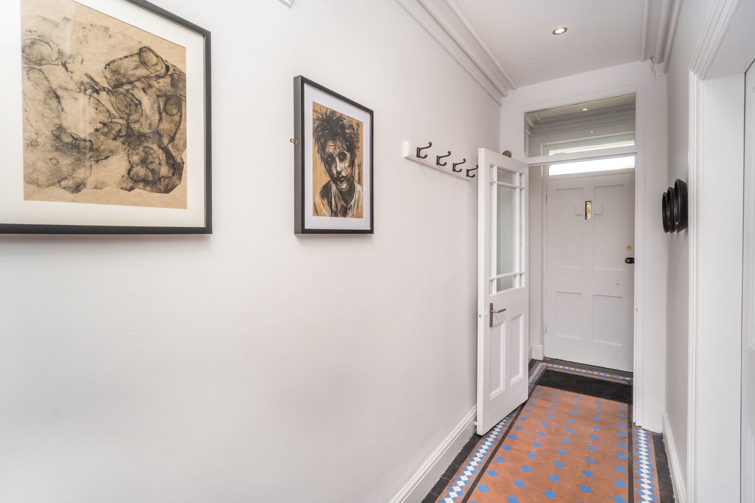 The property retains some original features, including the attractive floor tiles in the hallway