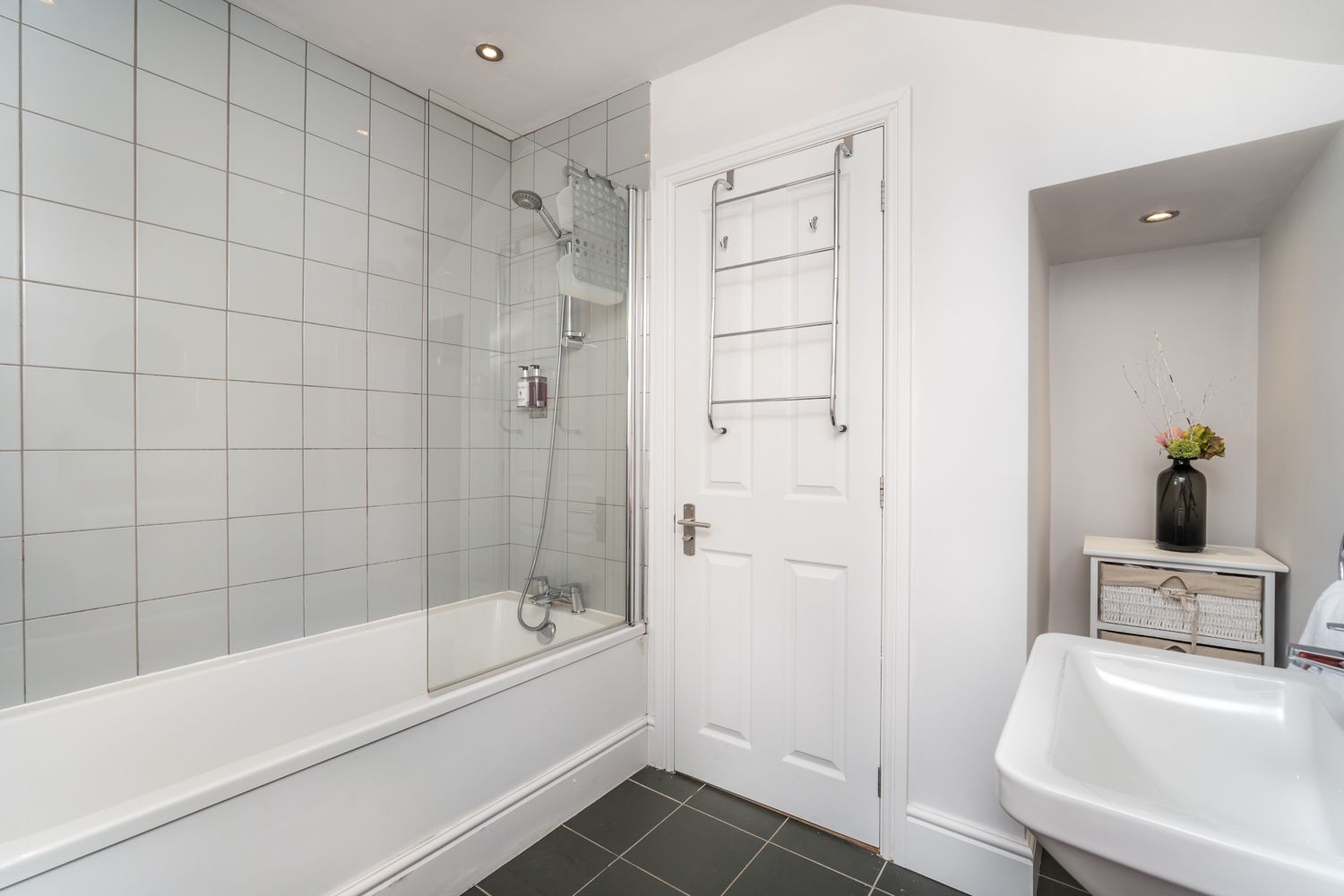 The bathroom comprises bath with overhead shower, hand sink and WC