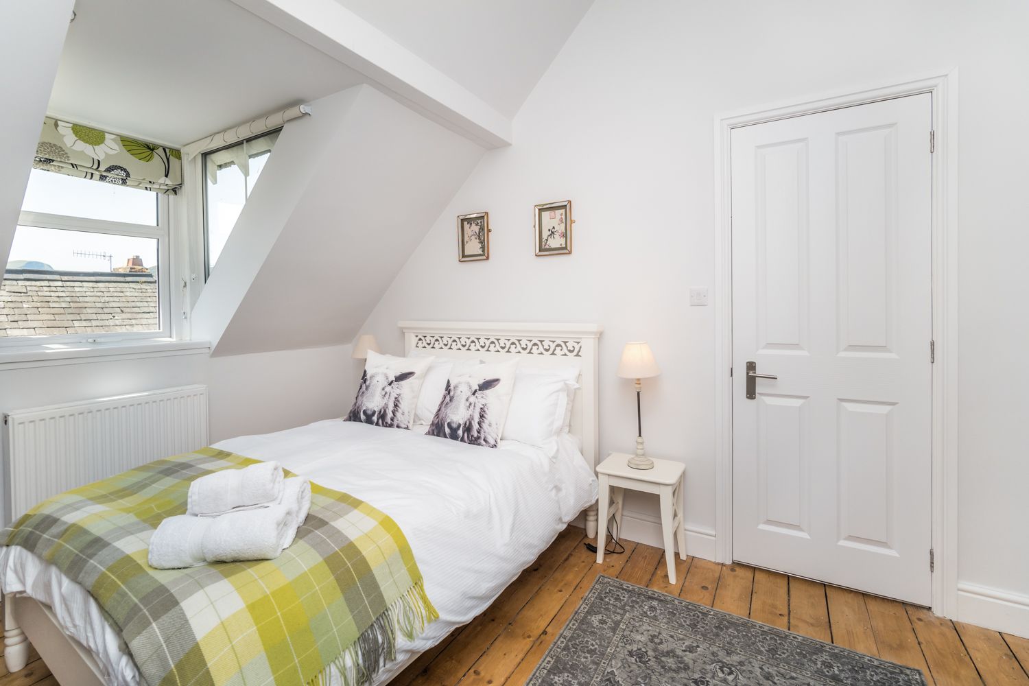 This bedroom is furnished with a double bed, wardrobe, chest of drawers and bedside tables