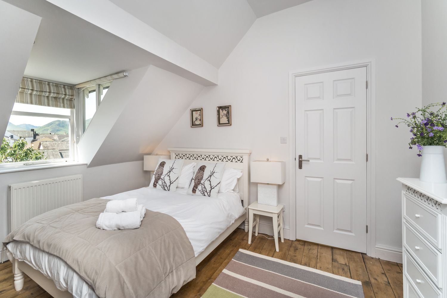 This bedroom is furnished with a double bed, wardrobe, chest of drawers and bedside tables