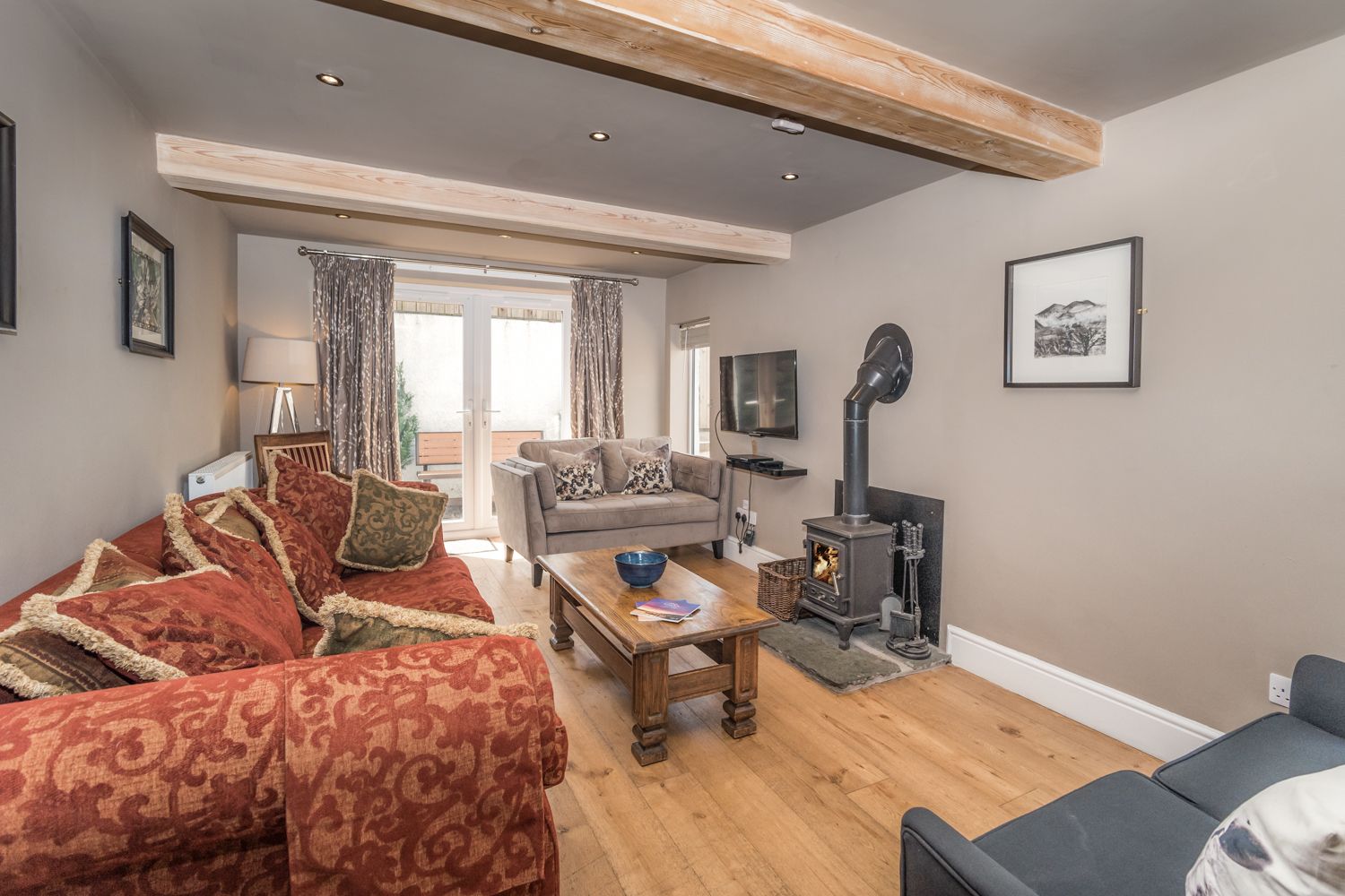The open plan living area and kitchen is to the rear of the property on the ground floor, and has a log burning stove to enjoy in the colder months