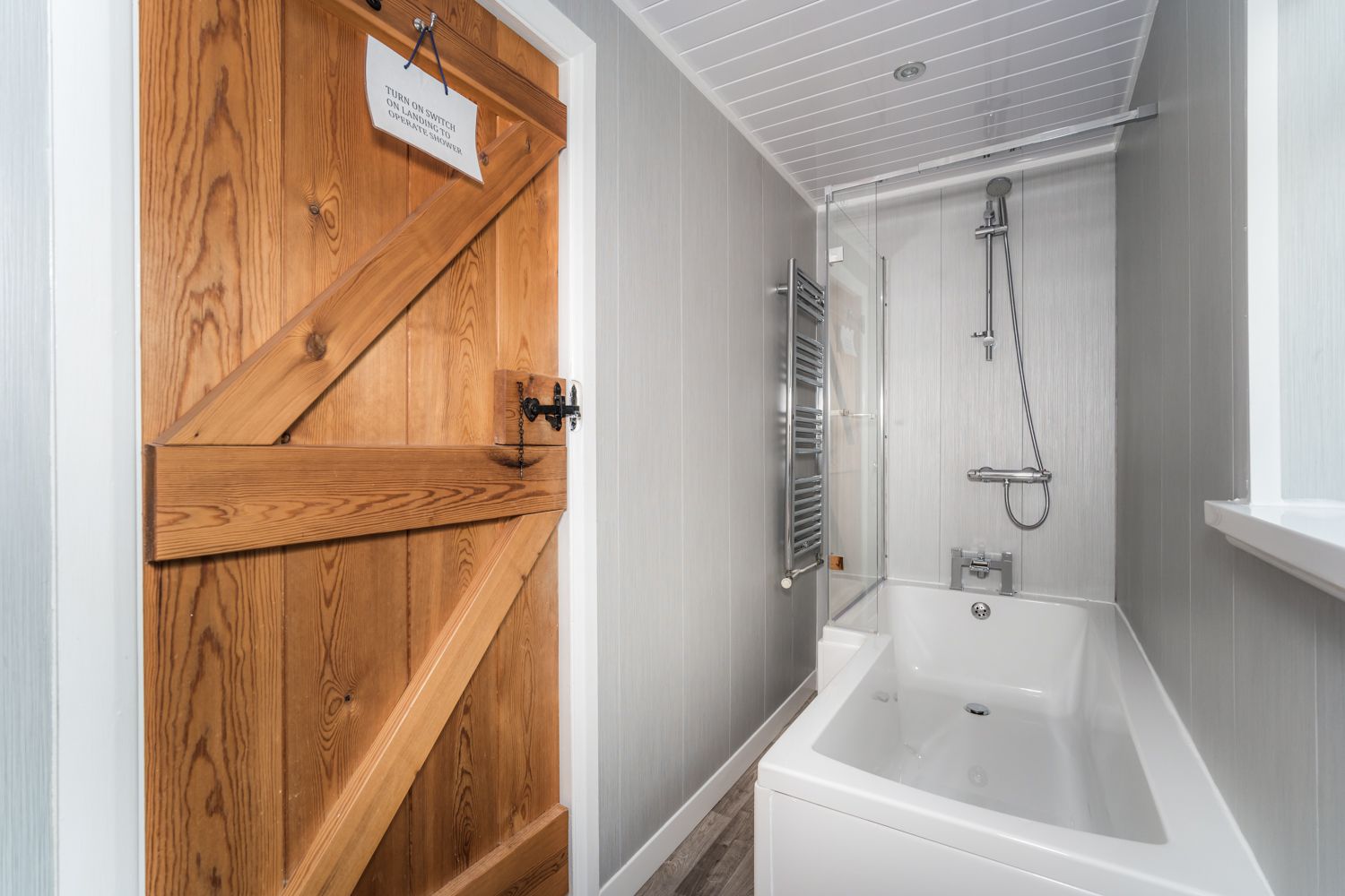 The main bathroom comprises bath with overhead shower, WC and hand basin