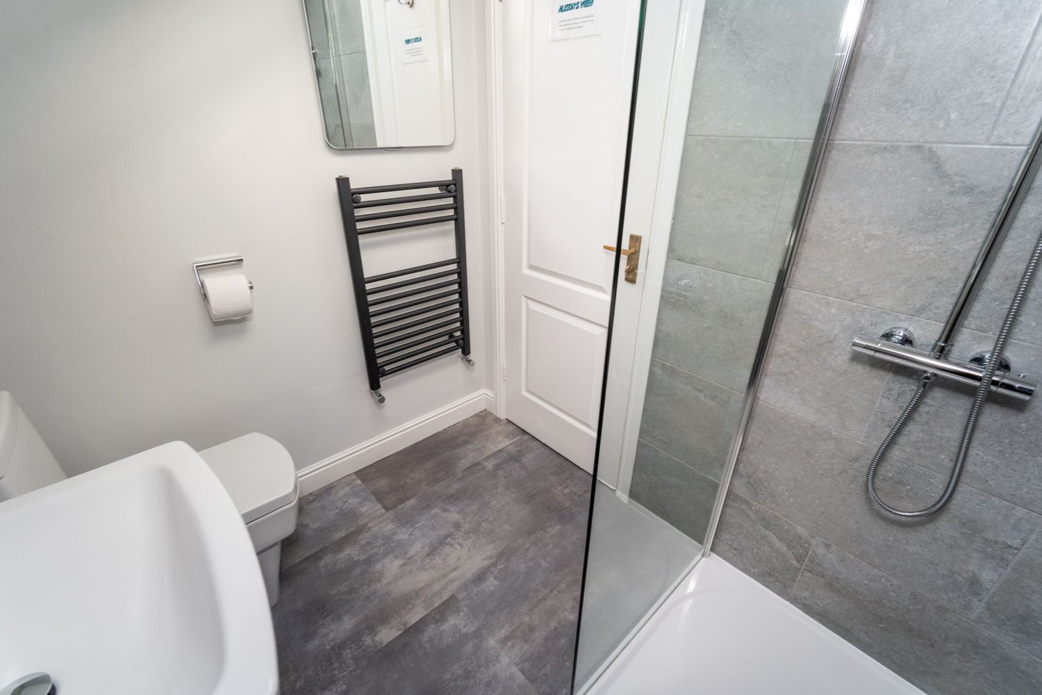 The bathroom has a large walk in shower and heated towel rail