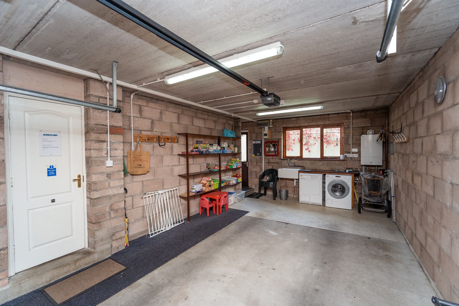 A large garage with utility area can be used to store bikes and prams