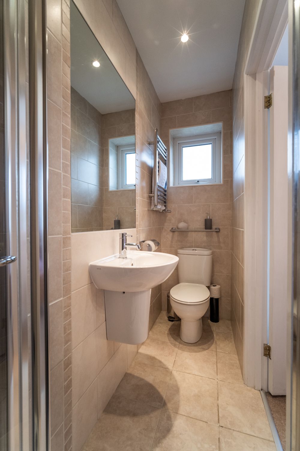 The modern ensuite features a walk in shower and heated towel rail