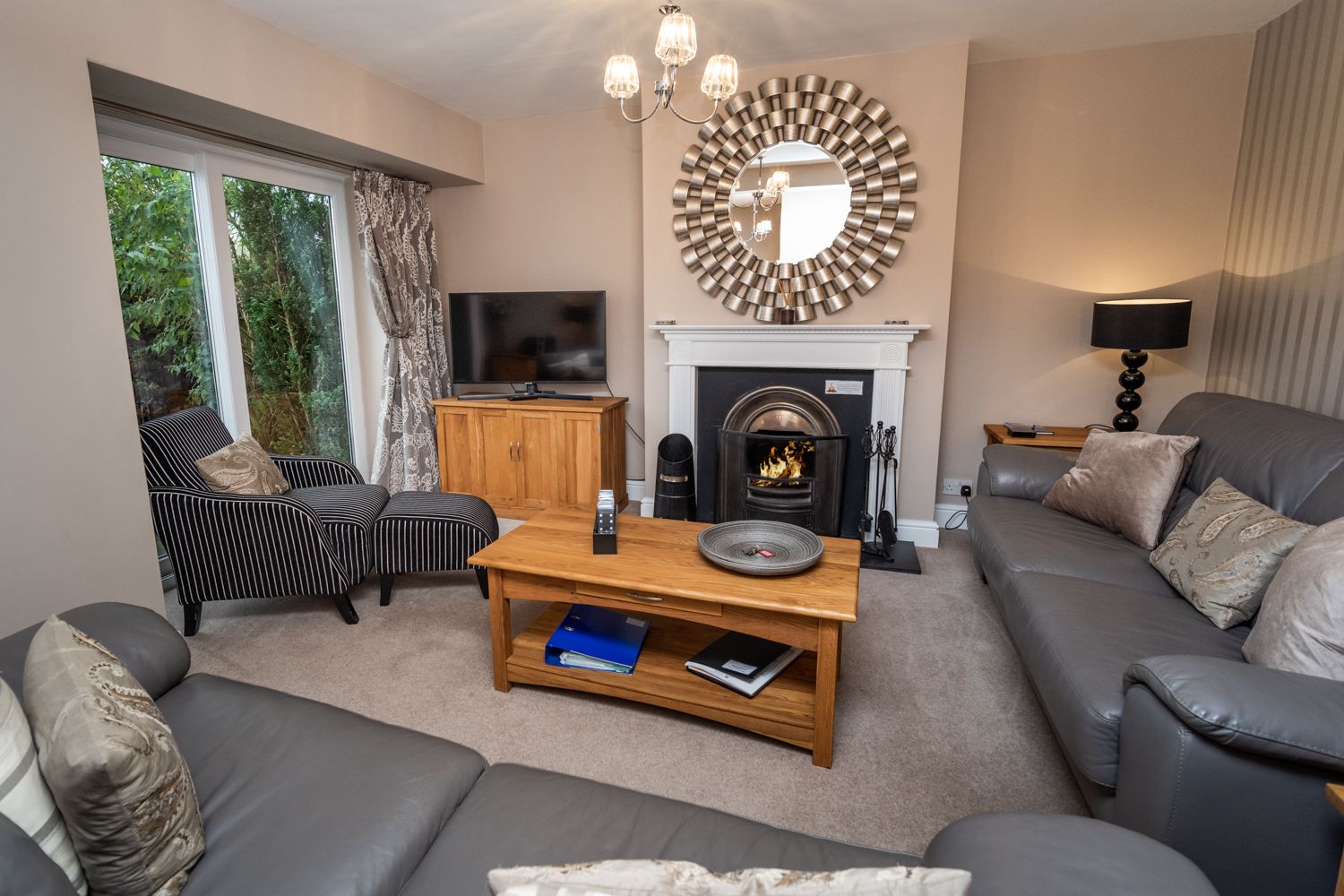 The living area boasts an open fire, double doors to the patio and smart TV