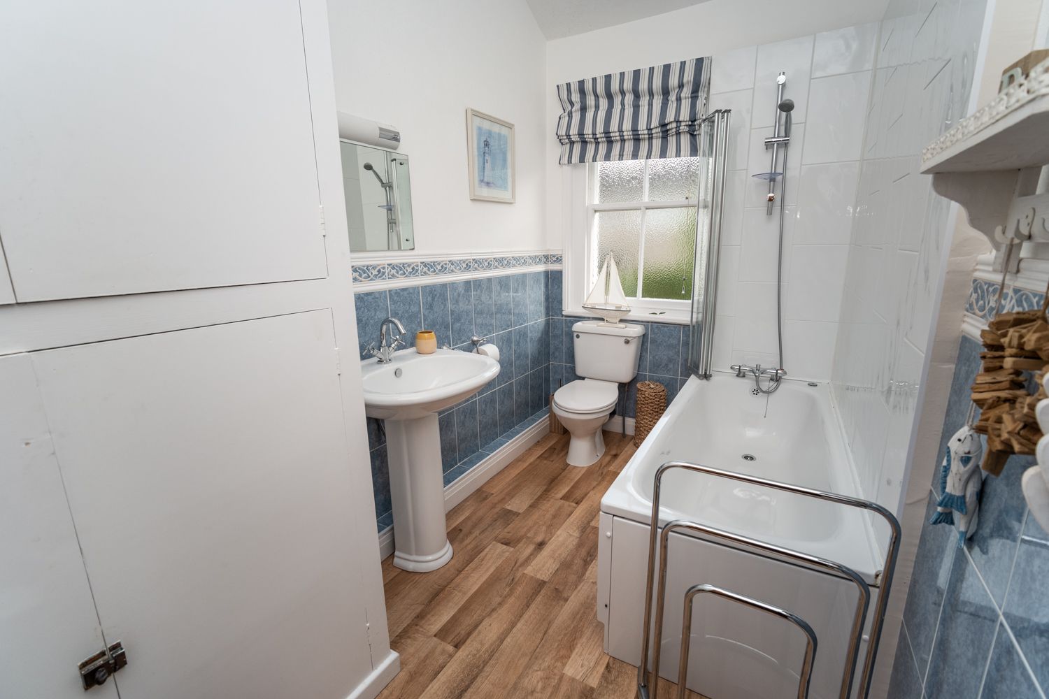 The bathroom comprises bath, overhead shower, WC and hand basin