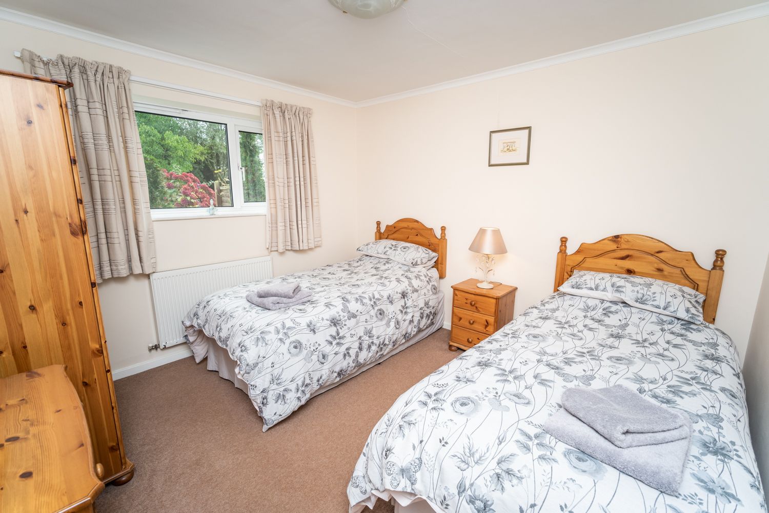 2 single beds, wardrobe and dressing table are provided in the pretty twin bedroom