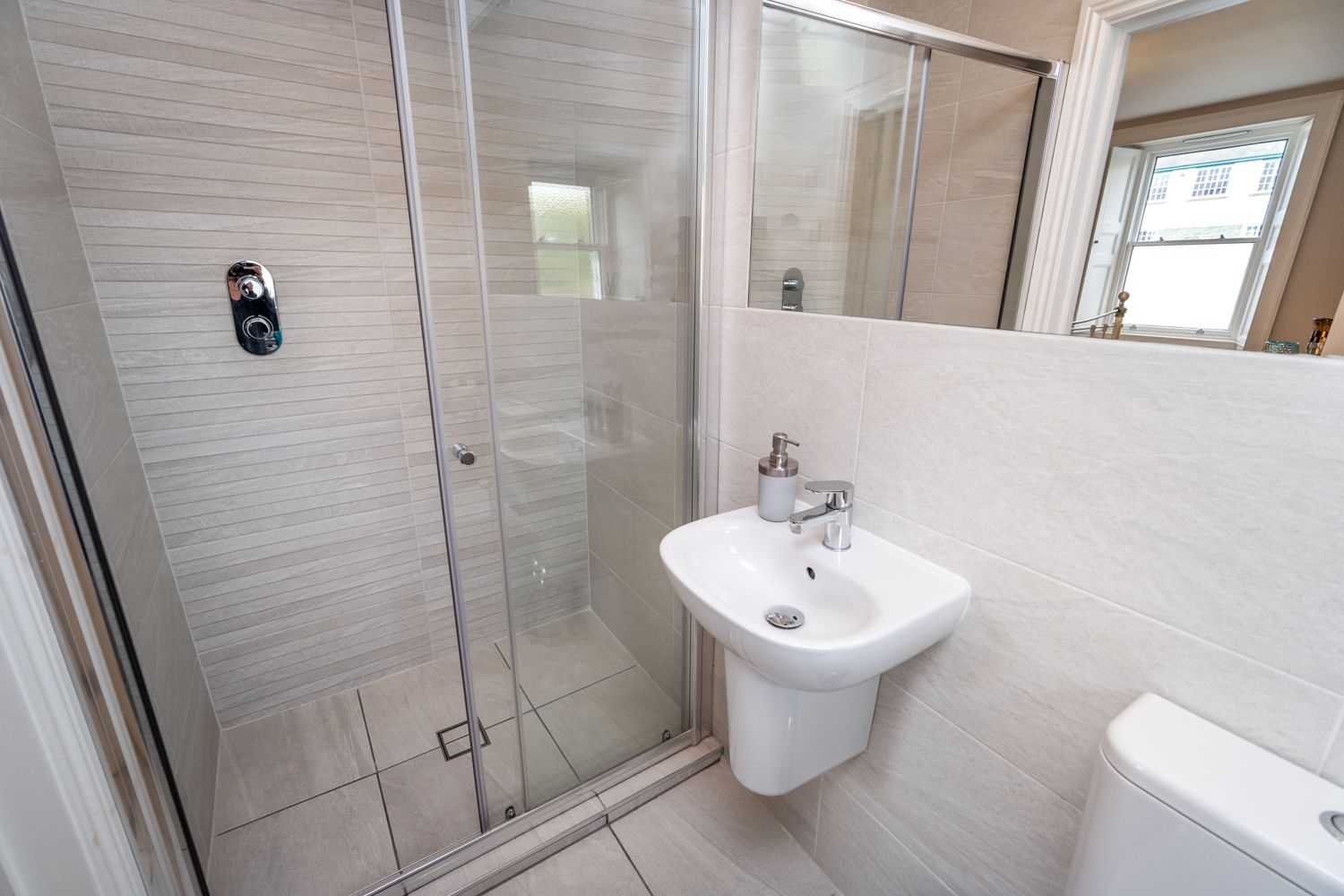 The ensuite to the ground floor bedroom features a large walk in shower, hand sink and WC
