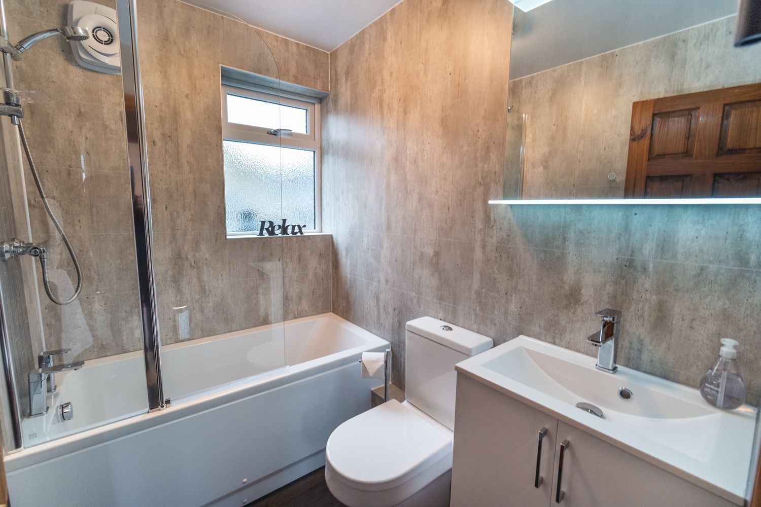 The modern bathroom benefits from a bath as well as overhead shower