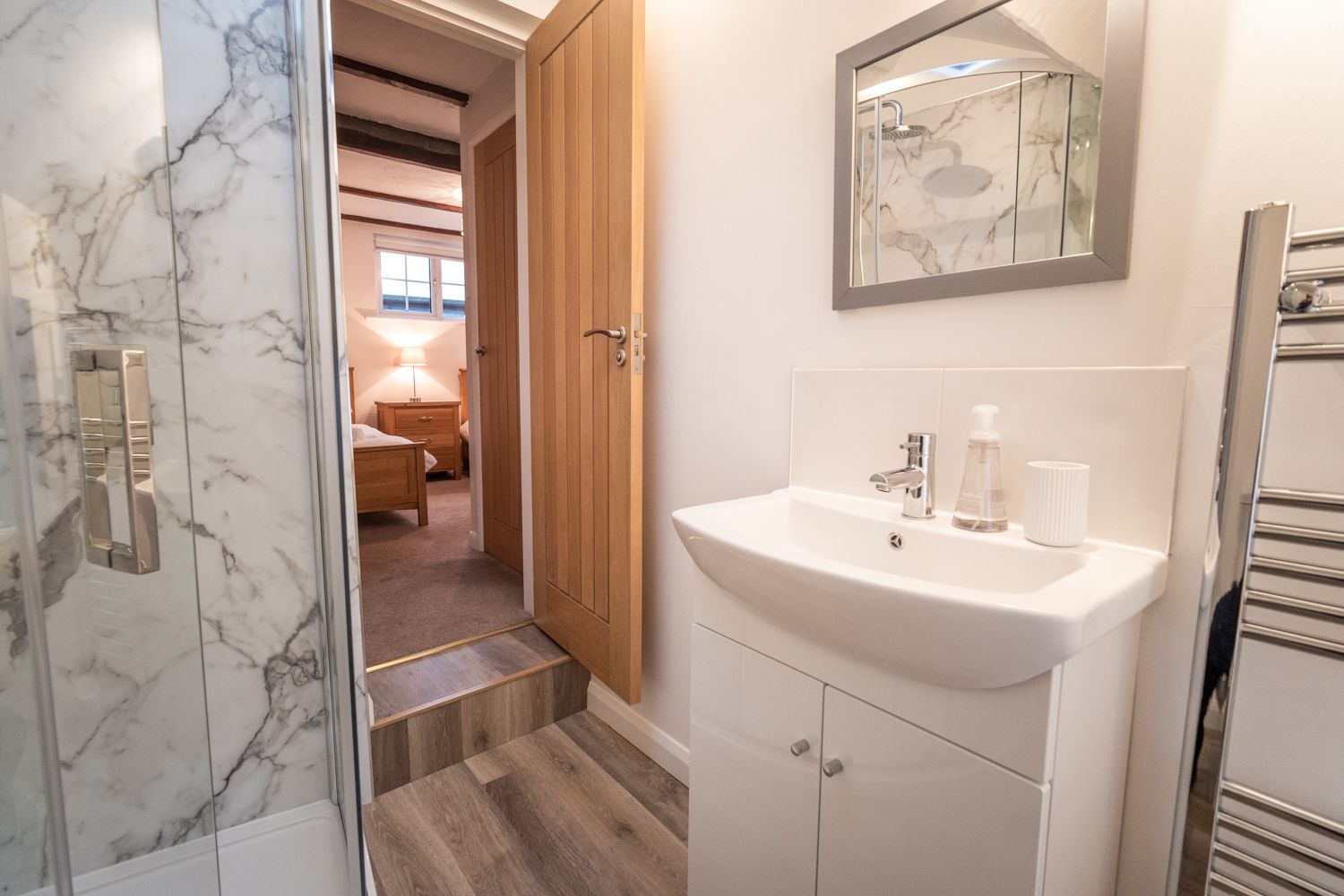 The ensuite to the twin room comprises a walk-in shower, WC, hand basin and heated towel rail