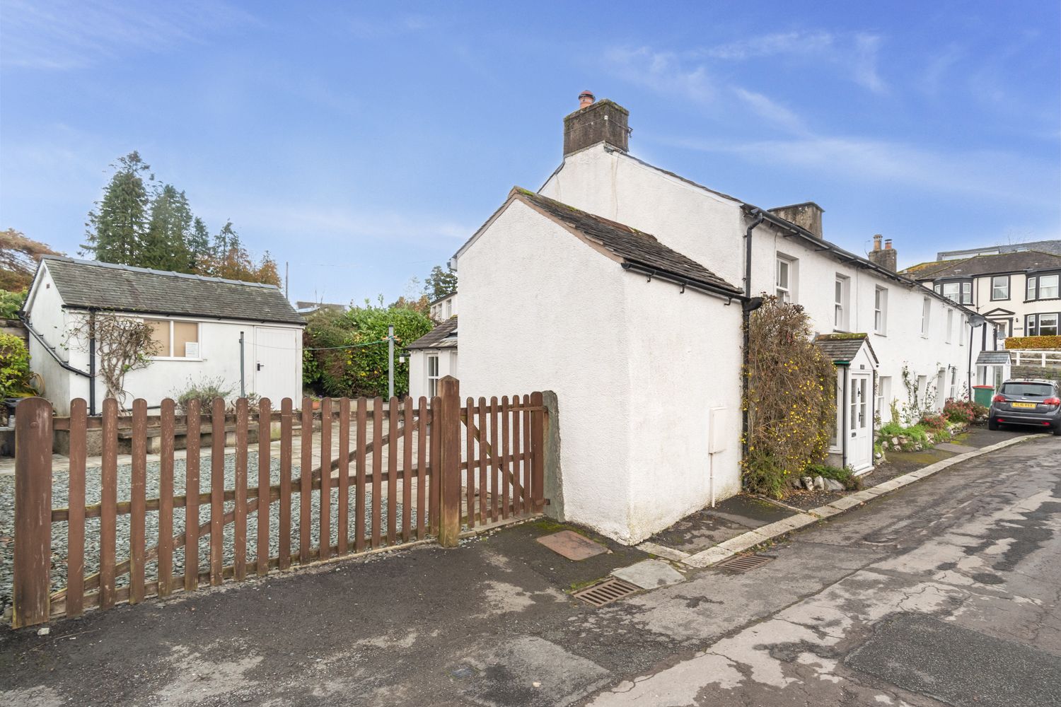 The wooden gate leads to the yard and rear entrance to the property
