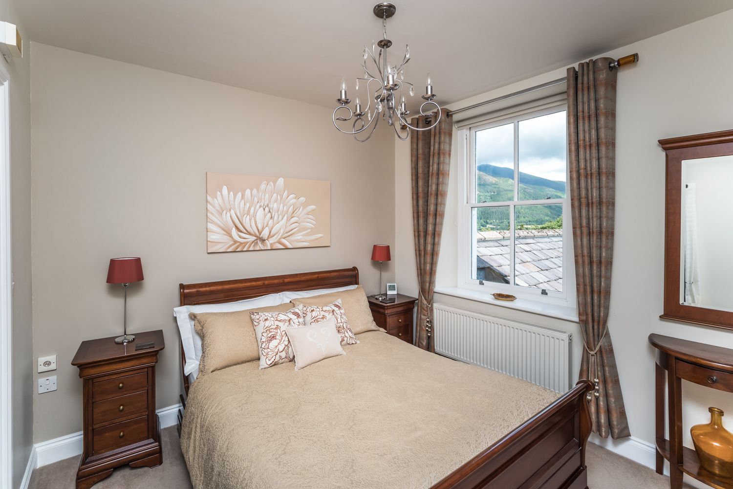 The master bedroom is furnished with a king sized bed, bedside tables and wardrobe
