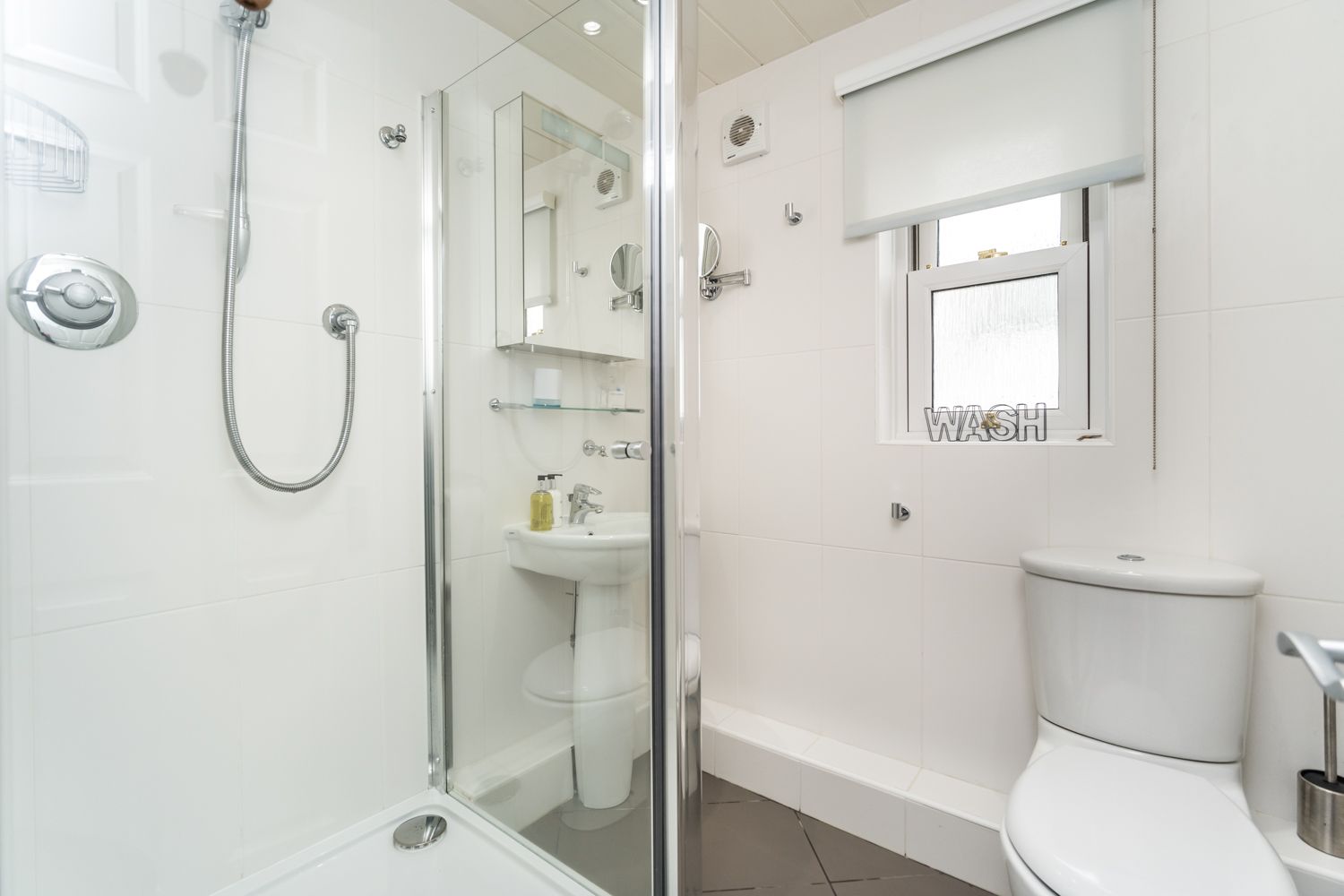 The bathroom features walk in shower and heated towel rail