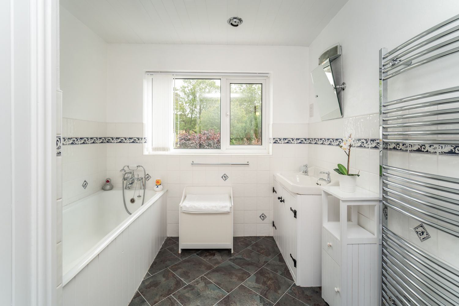 The bathroom comprises bath and separate walk in shower, sink and heated towel rail