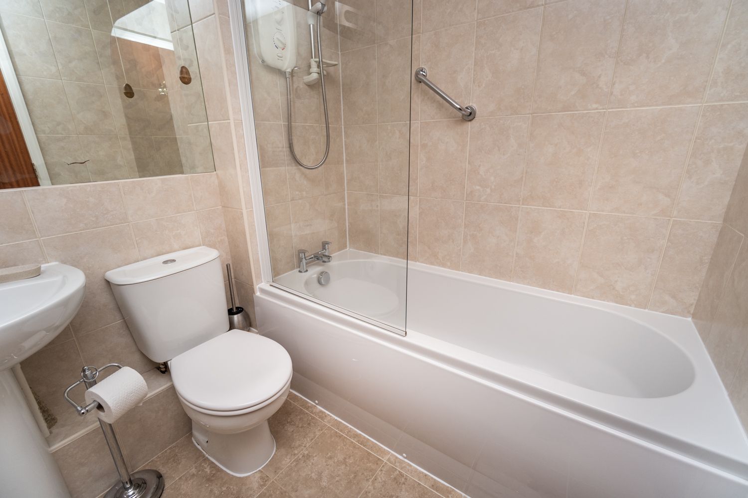 The bathroom comprises bath with overhead shower, hand sink and WC