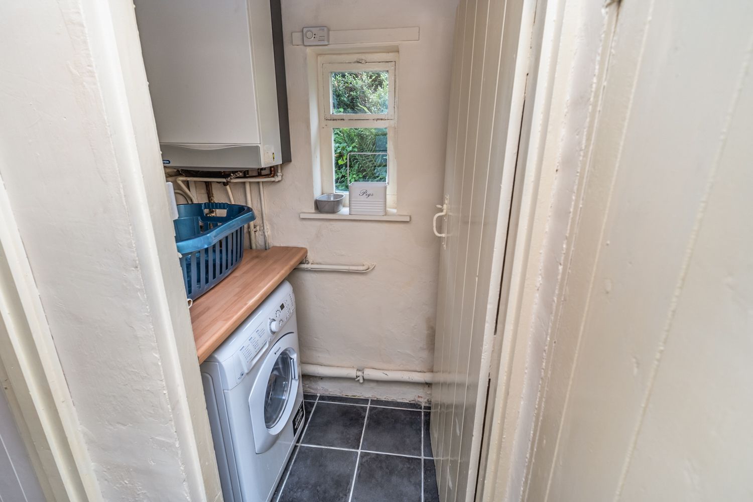 From the kitchen there is a small utility/drying area with a washer/dryer