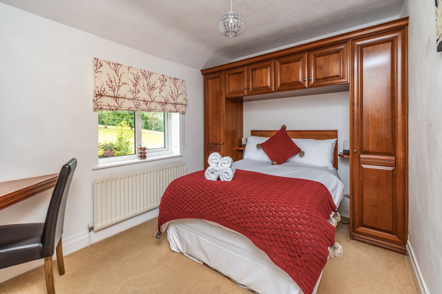 The master bedroom is furnished with a double bed, fitted wardrobes and dressing table