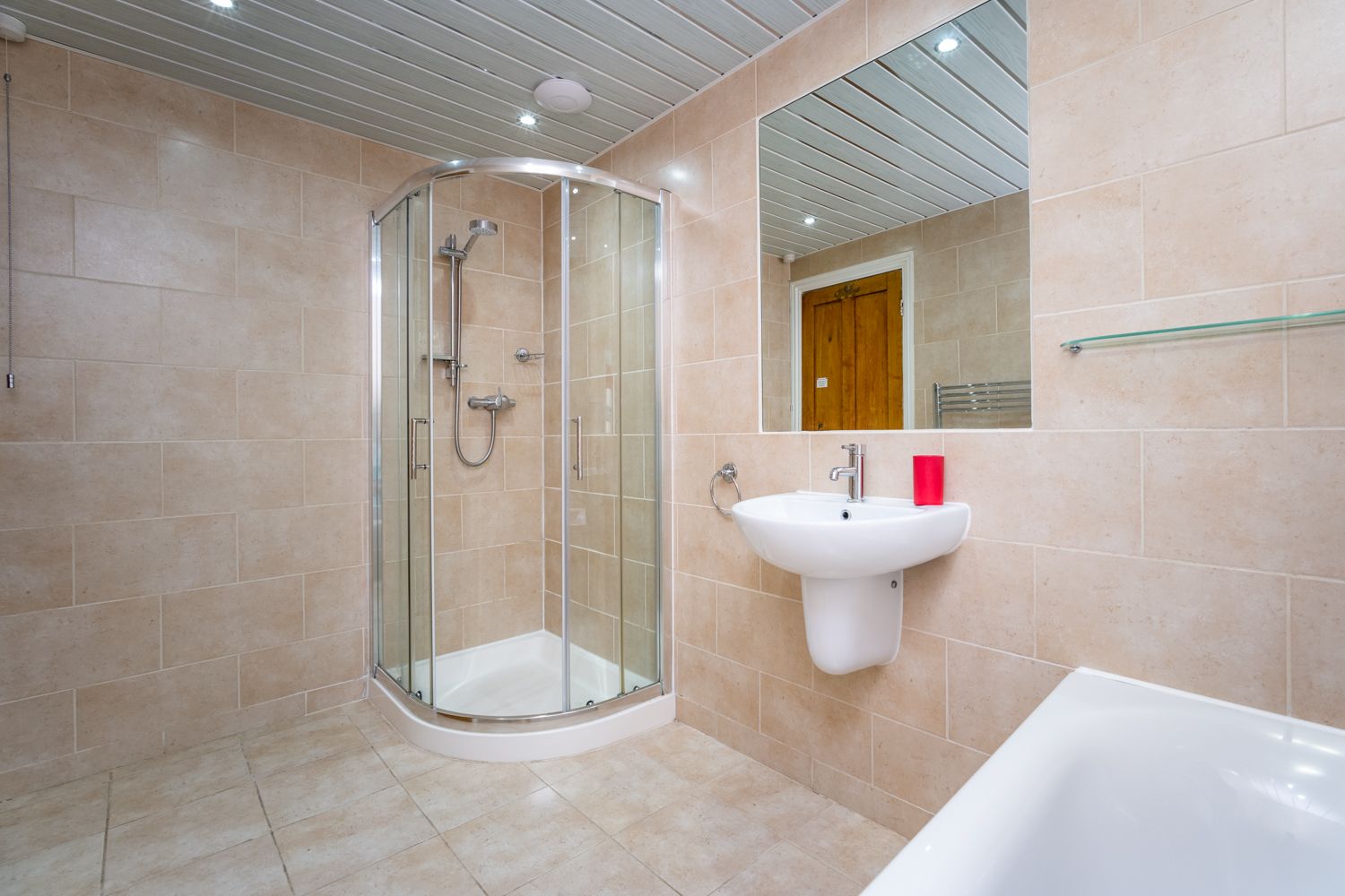 The family bathroom comprises a bath, separate walk in shower and hand basin