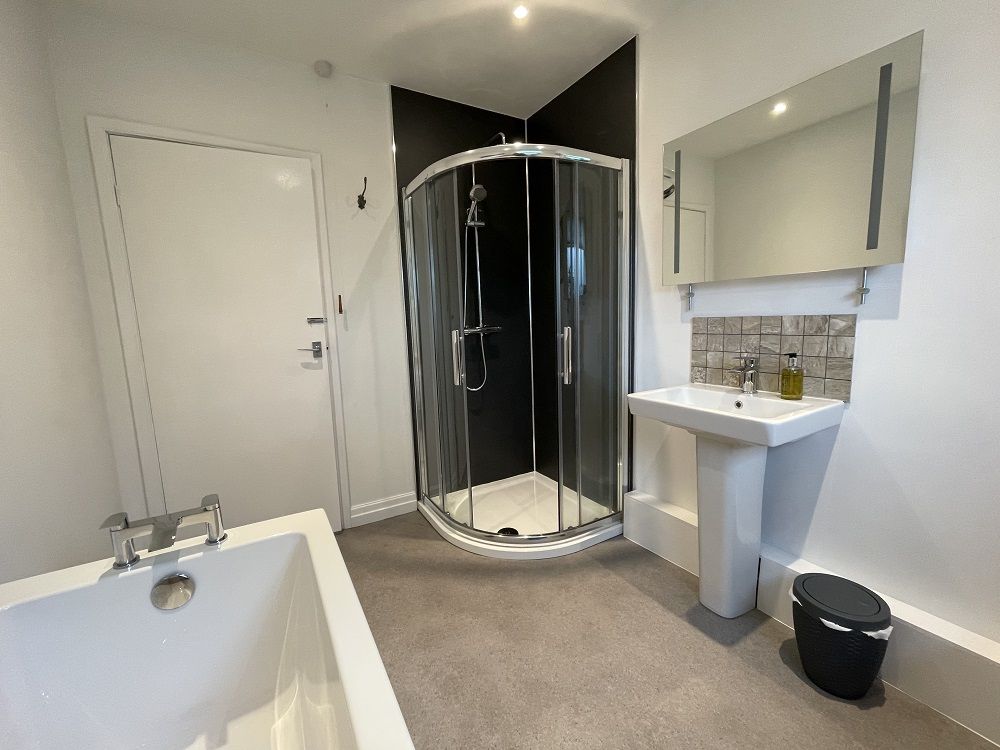 The bathroom comprises a bath, walk in shower, WC, hand sink and heated towel rail