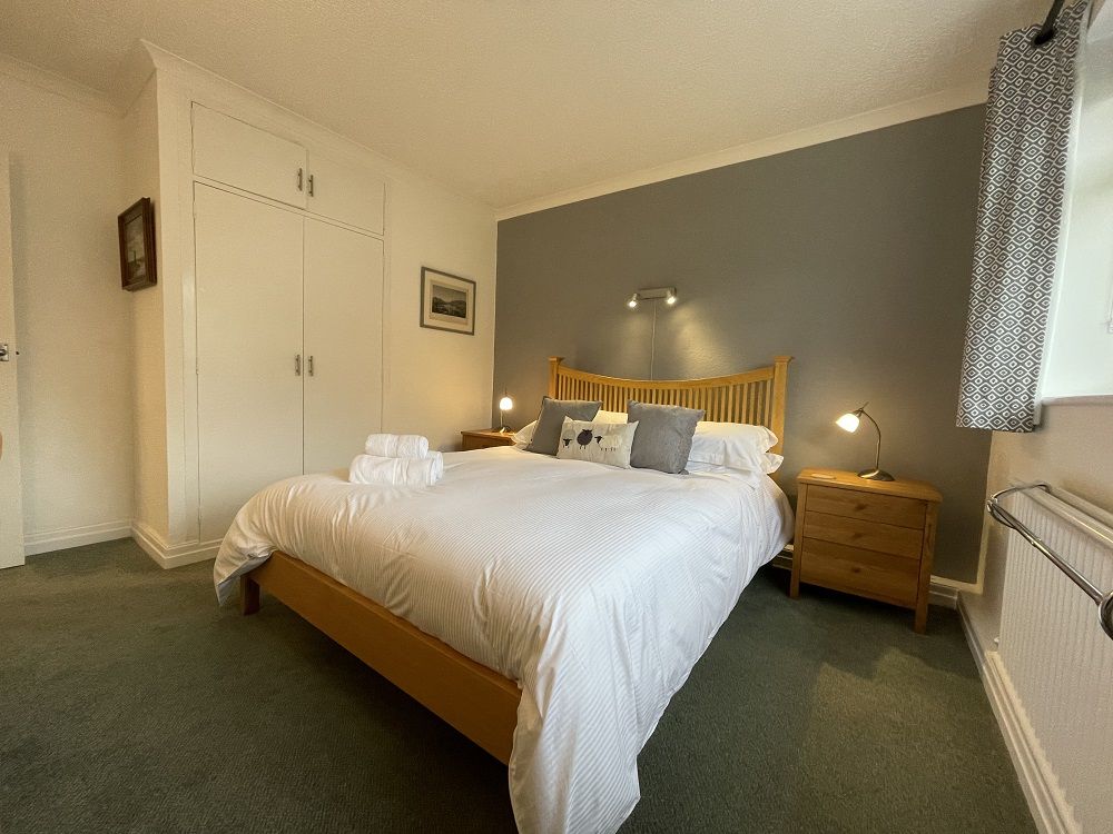 The master bedroom is furnished with a king sized bed and oak furniture