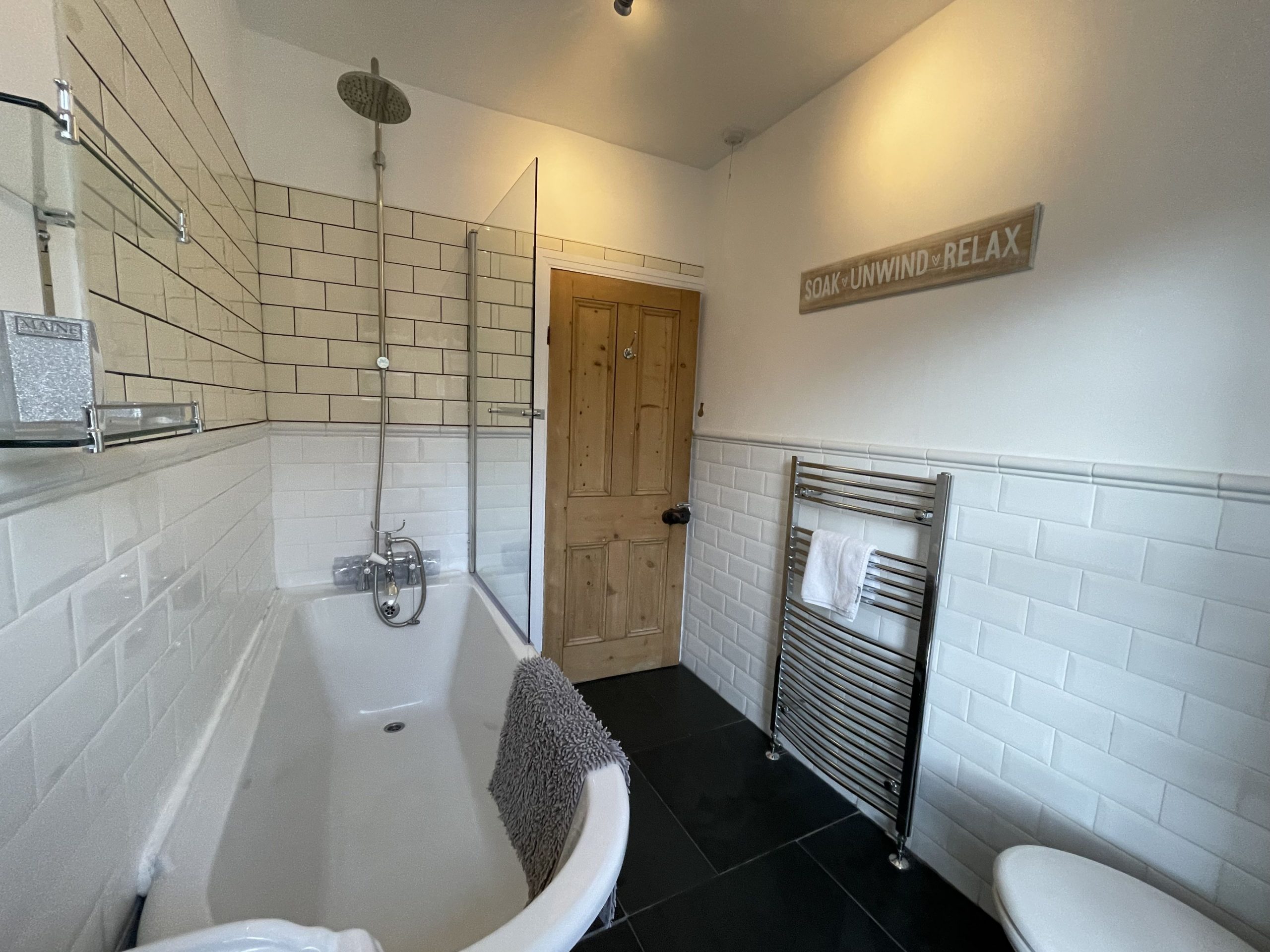 The bathroom comprises free standing bath with overhead shower, sink, WC and heated towel rail