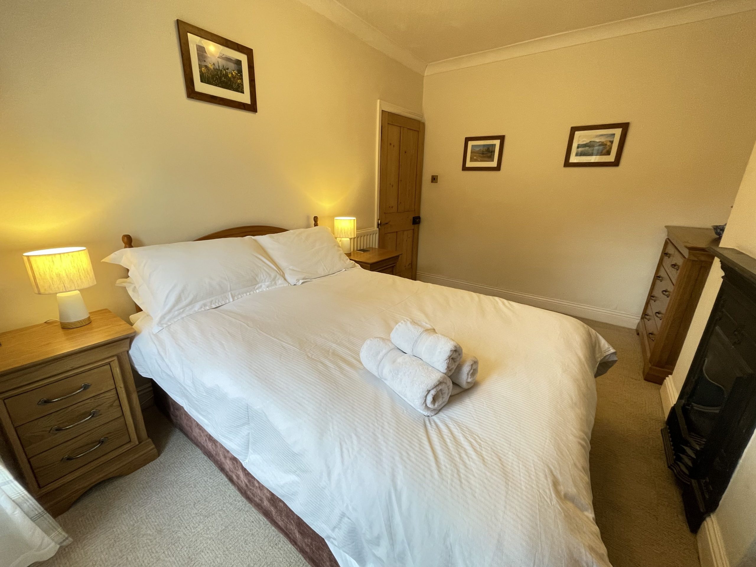 A double bed, bedside tables, wardrobe and drawers are provided