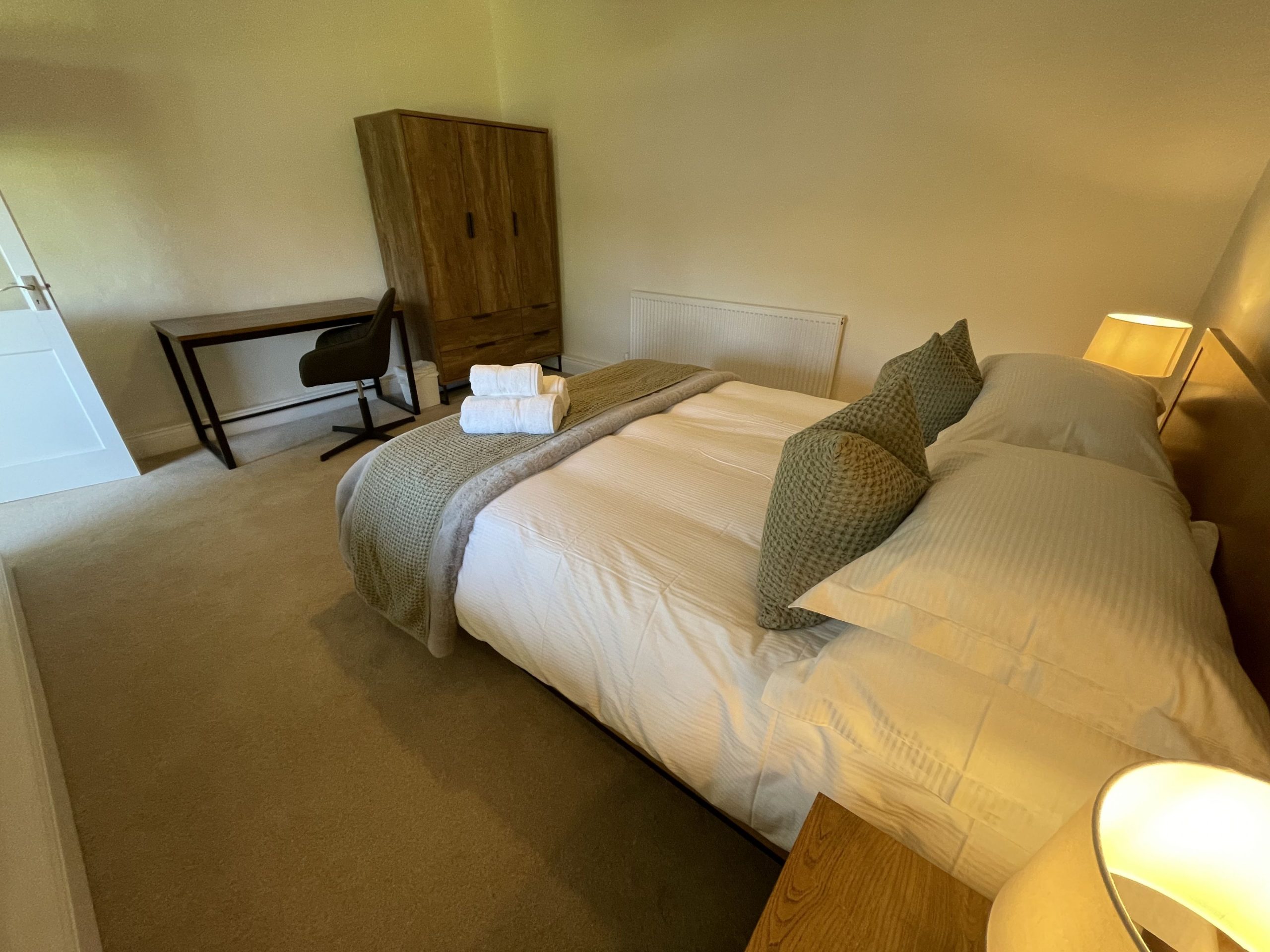 The second bedroom is furnished with double bed and bedside tables, wardrobe and desk