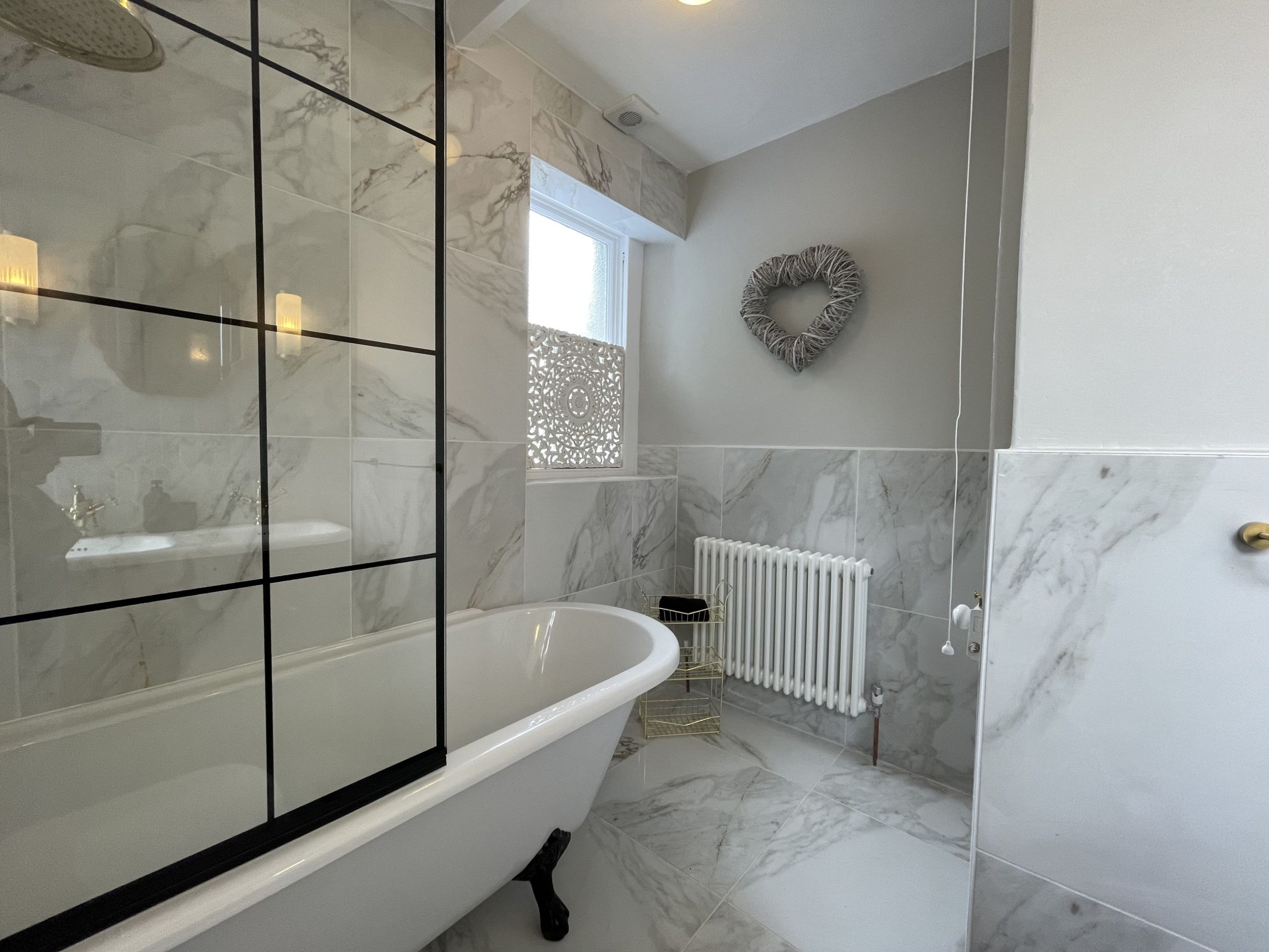 The bathroom comprises bath with overhead waterfall shower, sink and WC
