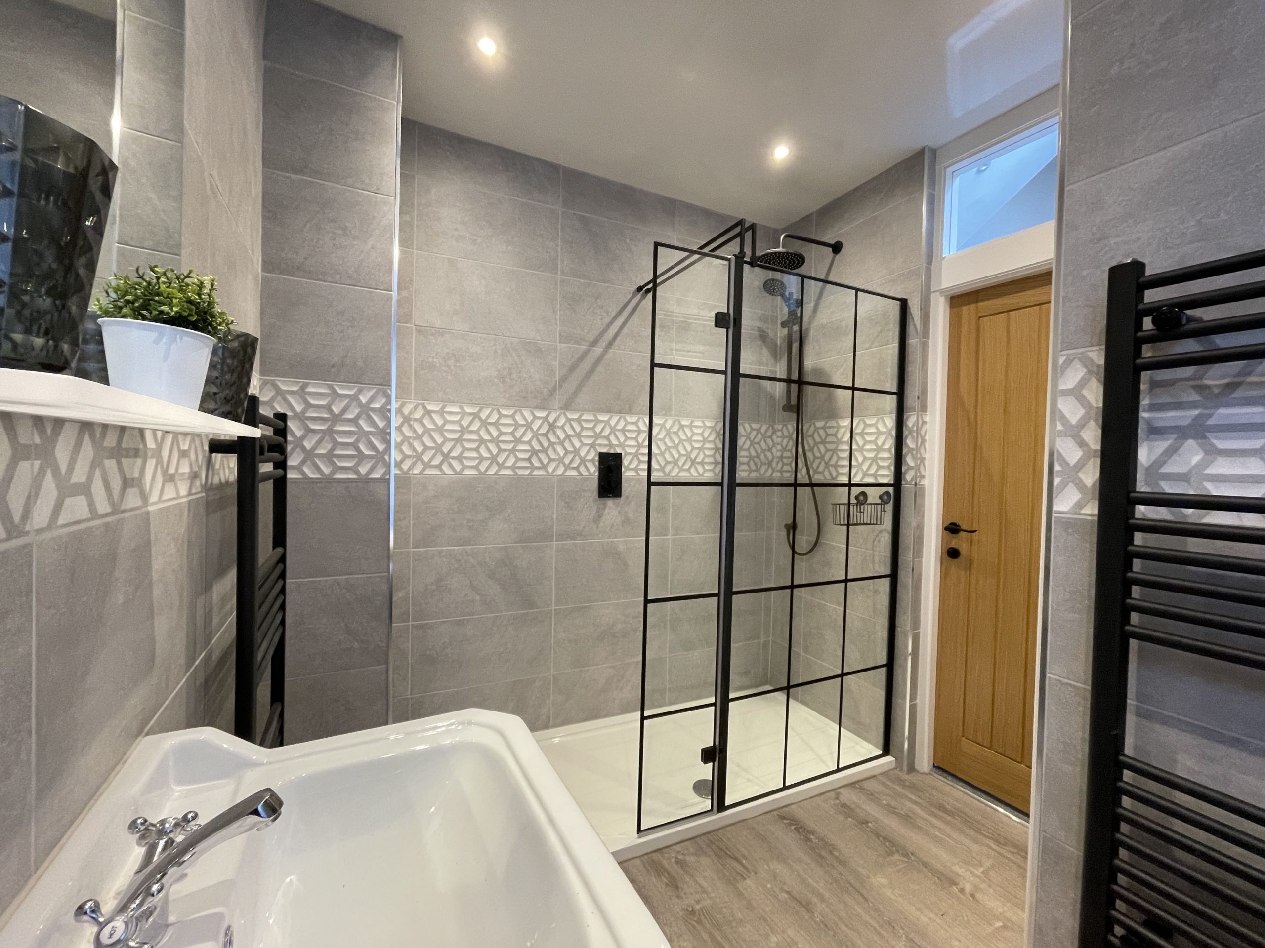 Stunning walk in shower room with drench shower and black panelled shower screen