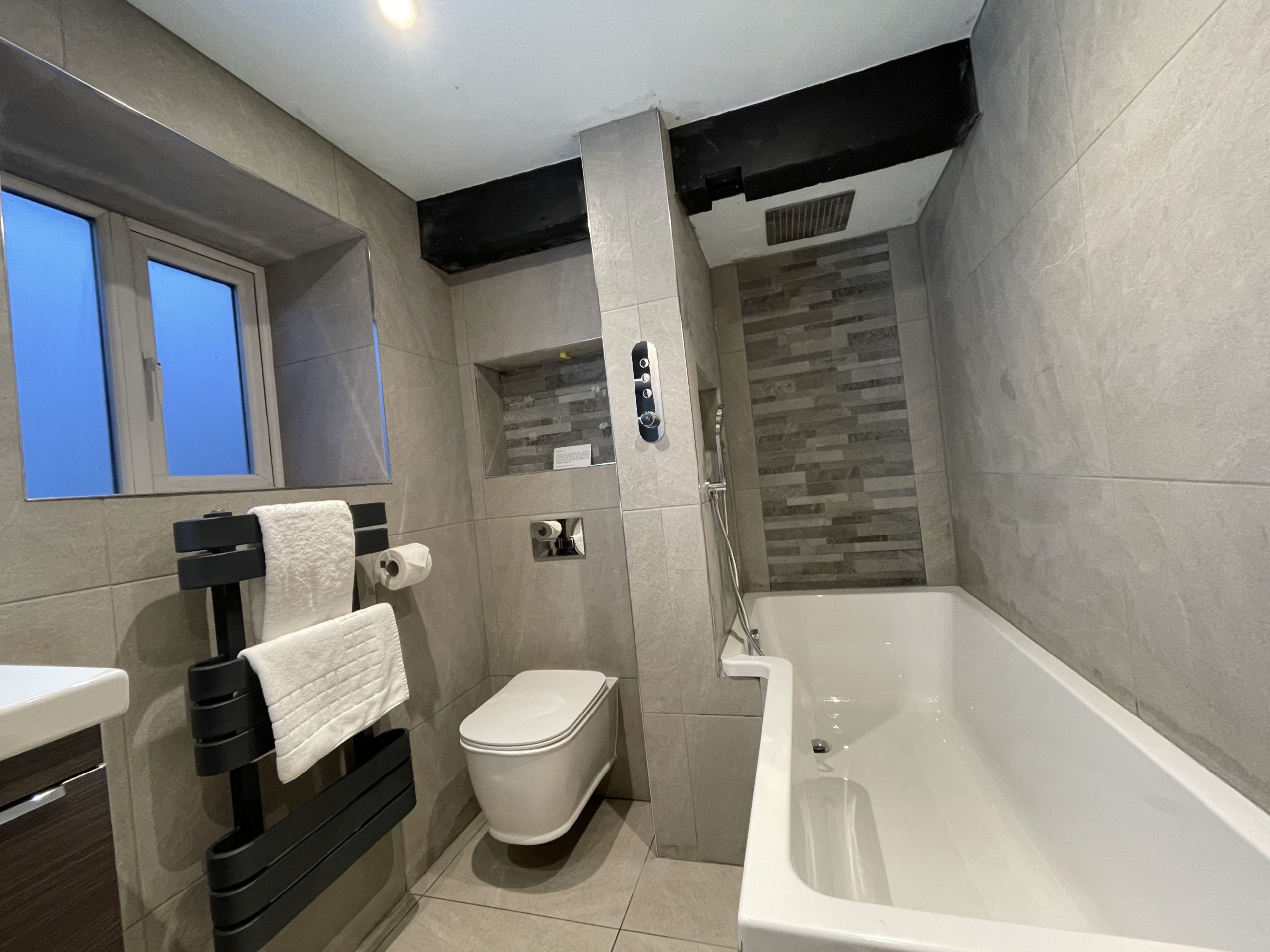 The ground floor bathroom comprises bath with overhead rainfall shower, hand sink WC and heated towel rail