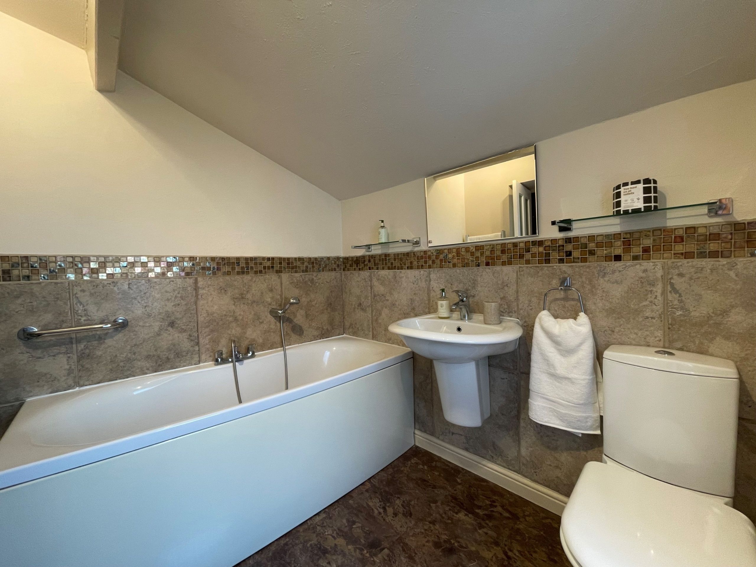 The family bathroom comprises of a bath with shower head, wash basin and WC