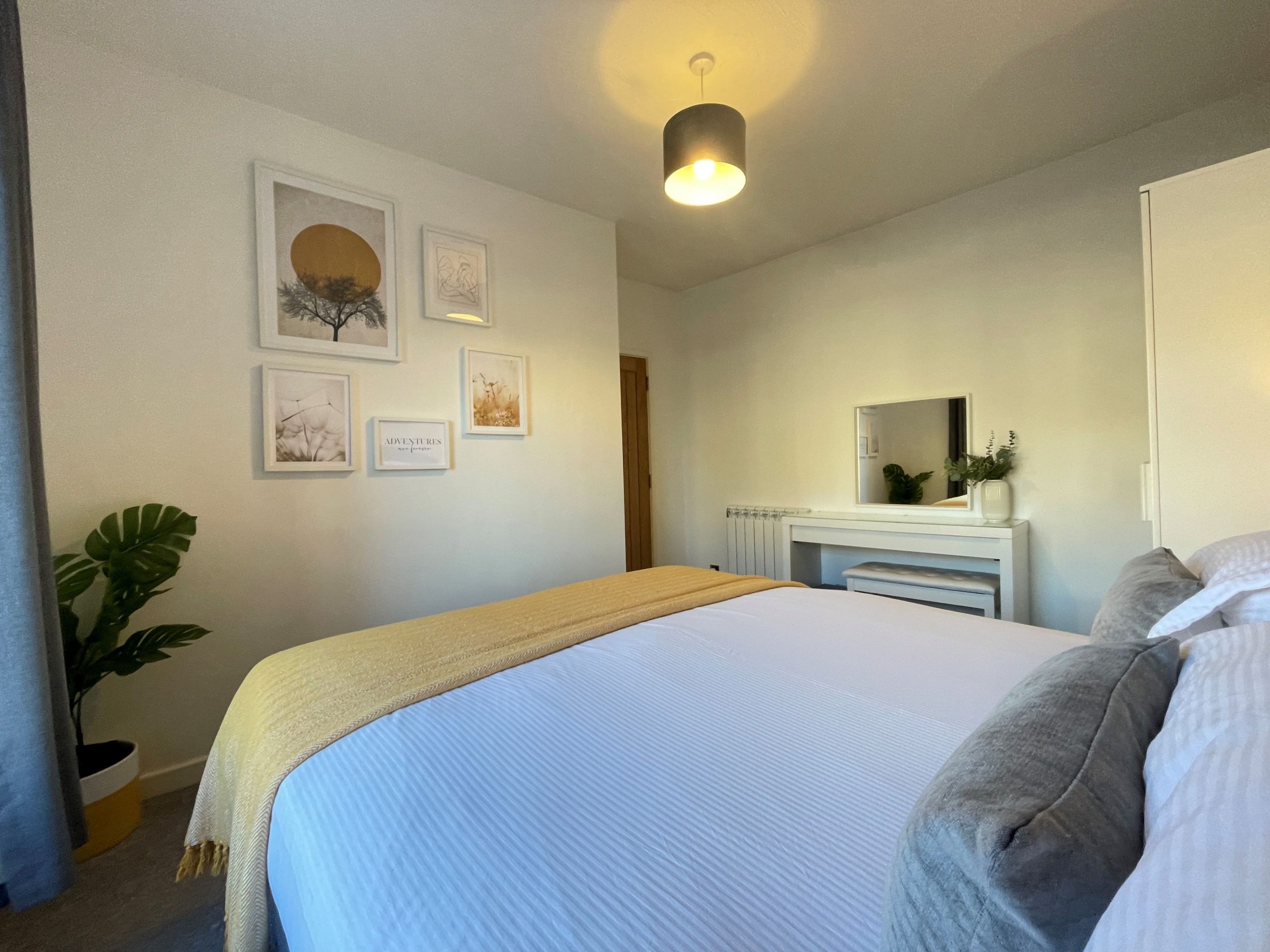 The bedroom is well decorated and has a comfortable double bed, dressing table and wardrobe space