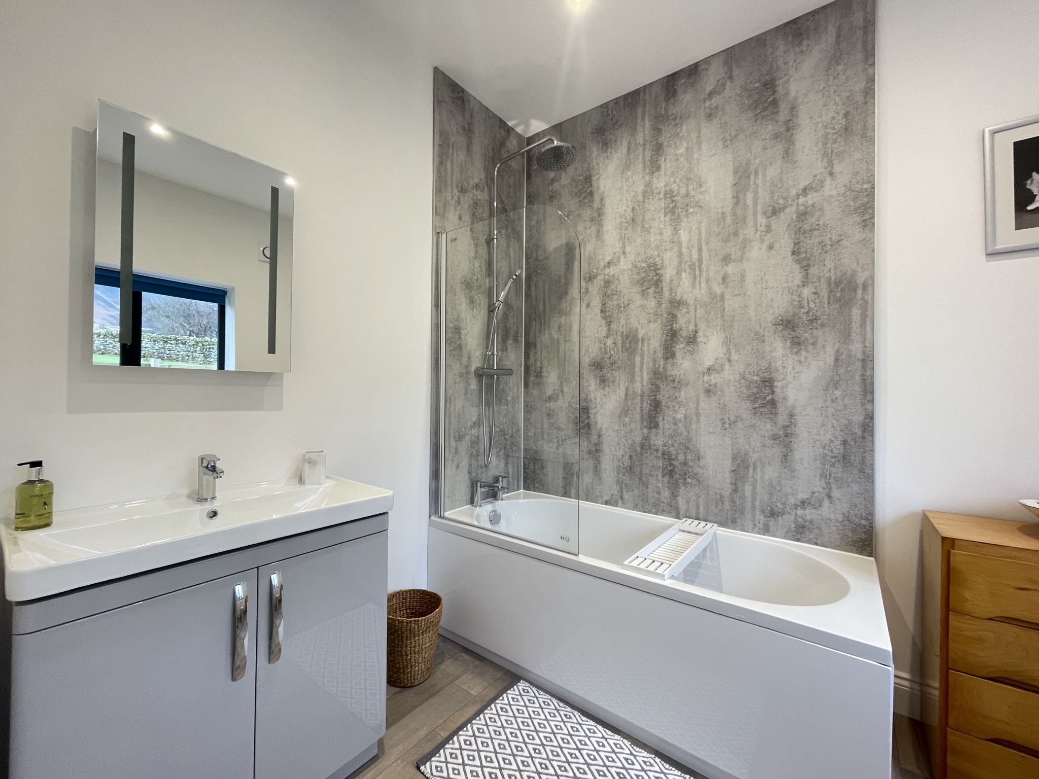 The main bathroom has a bath with overhead shower, WC and hand basin