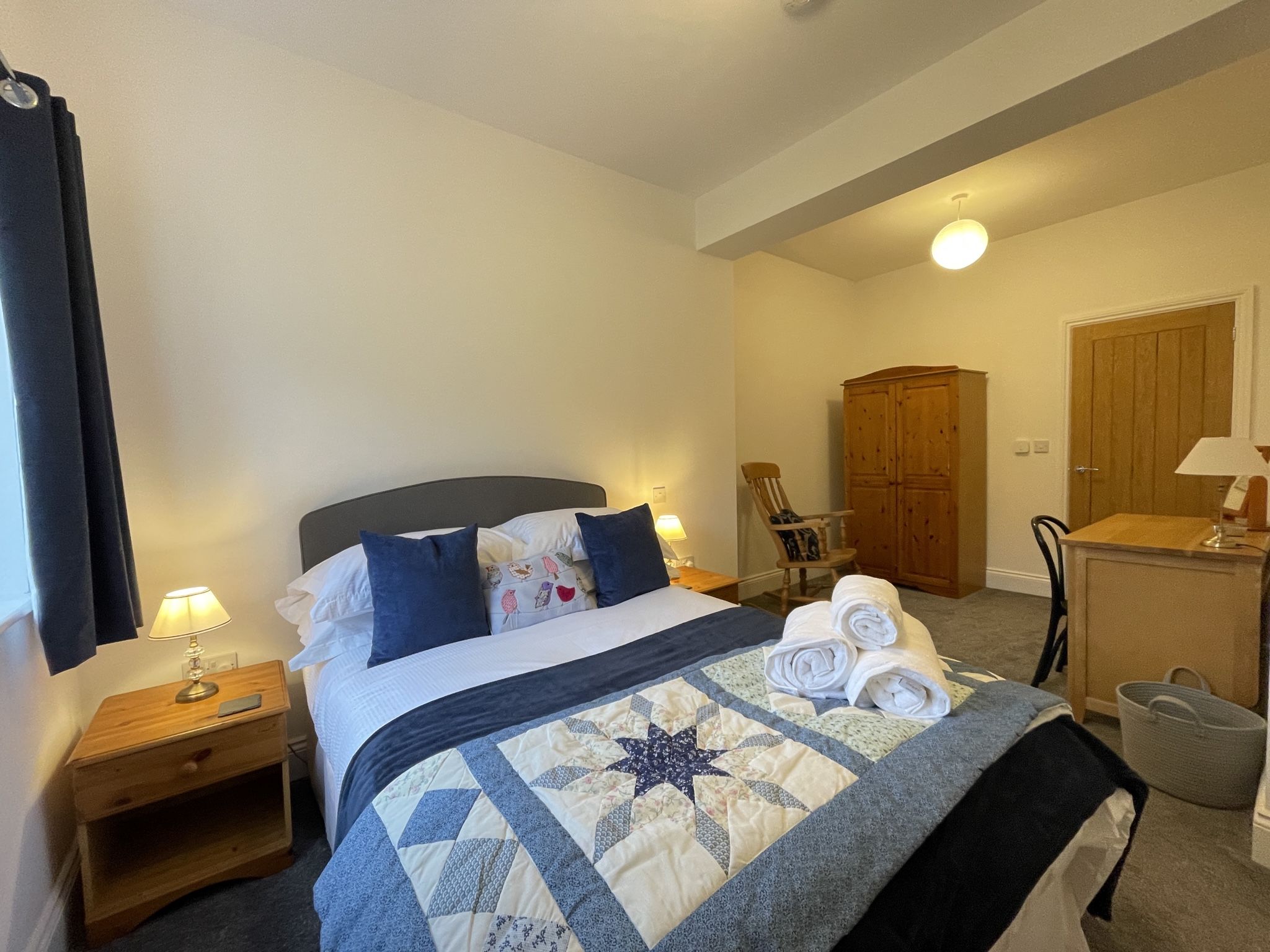 A double bed, wardrobe, dressing table and bedside tables are provided