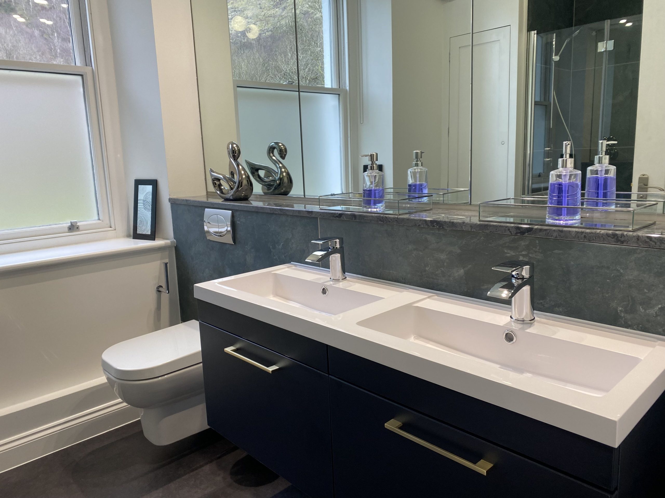 The modern bathroom with double basin, WC and bath with overhead shower