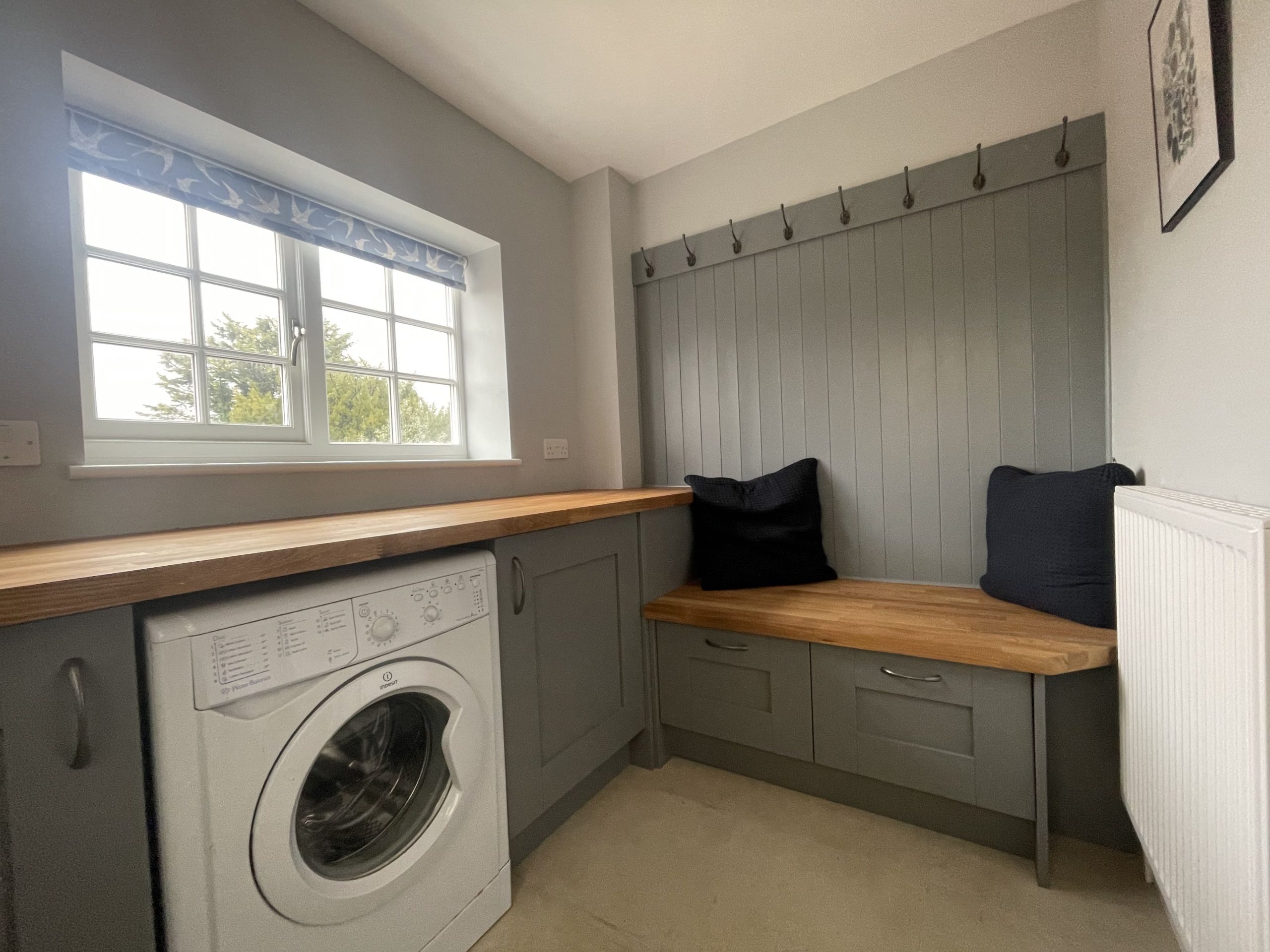 The back door opens into a utility area with washing machine and fitted bench