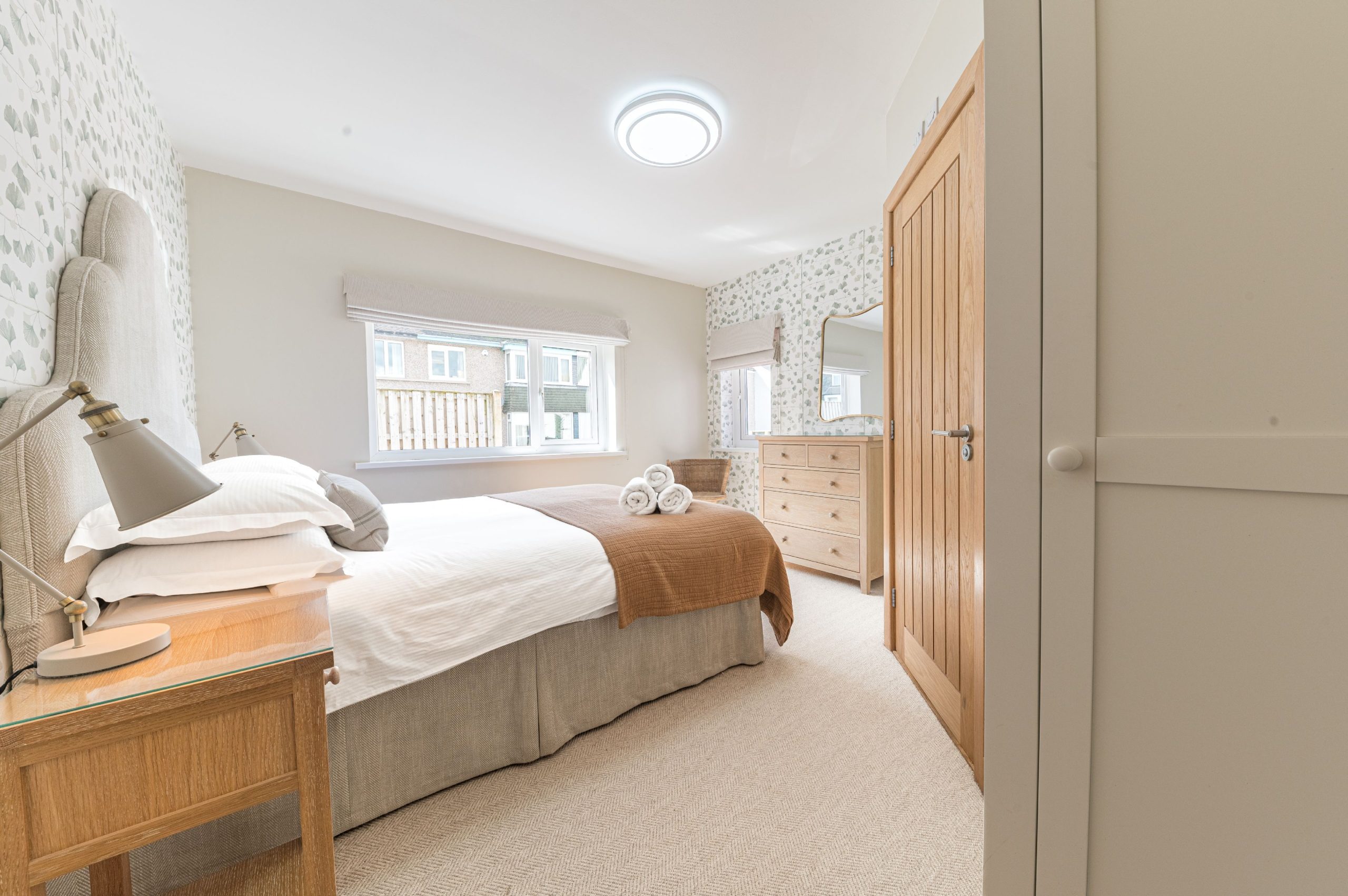The second downstairs bedroom has similar light and elegant decor