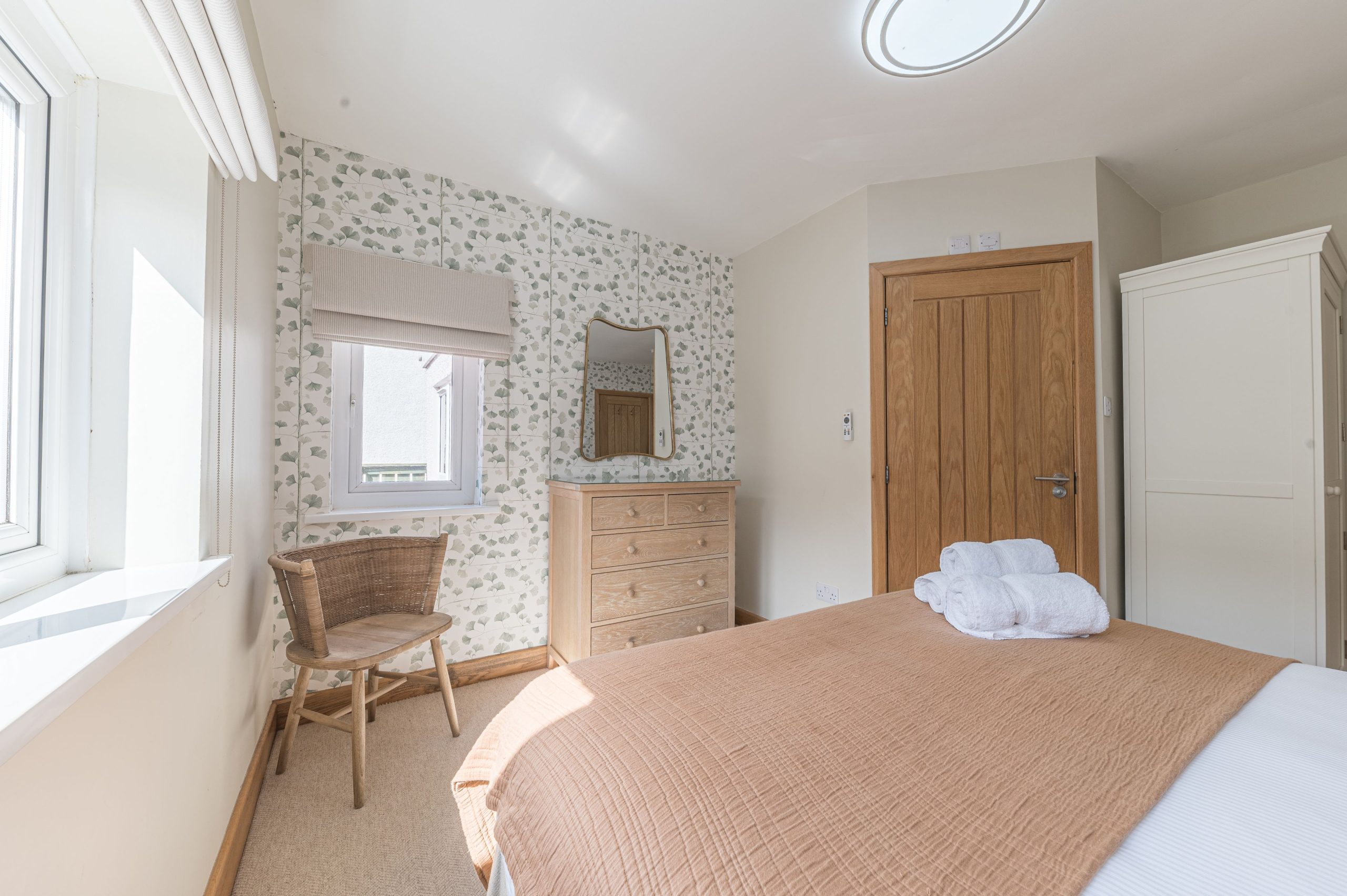 The room is furnished with a double bed, dressing table and wardrobe