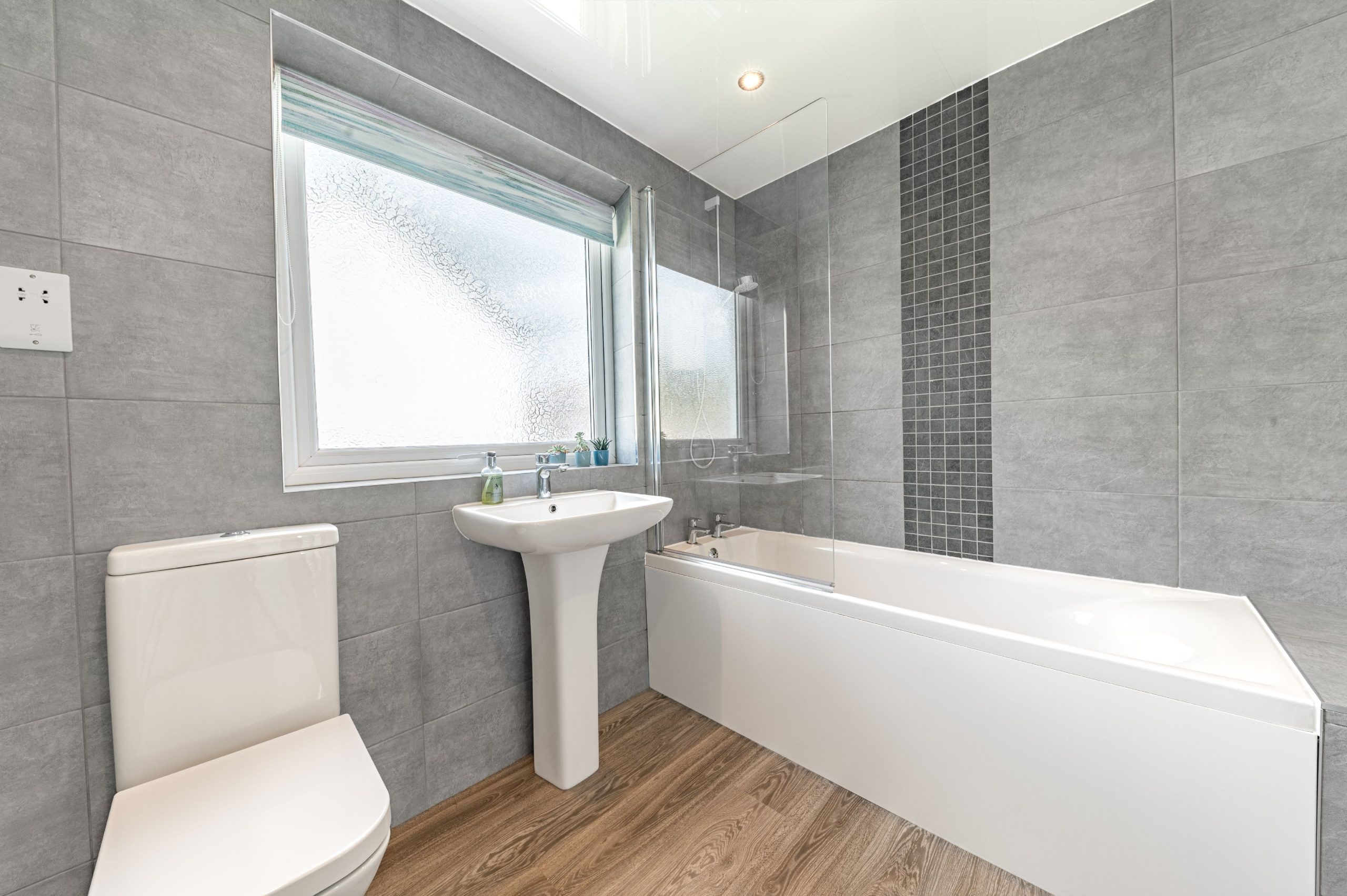 The modern bathroom upstairs comprises of a bath with overhead shower, WC and hand sink