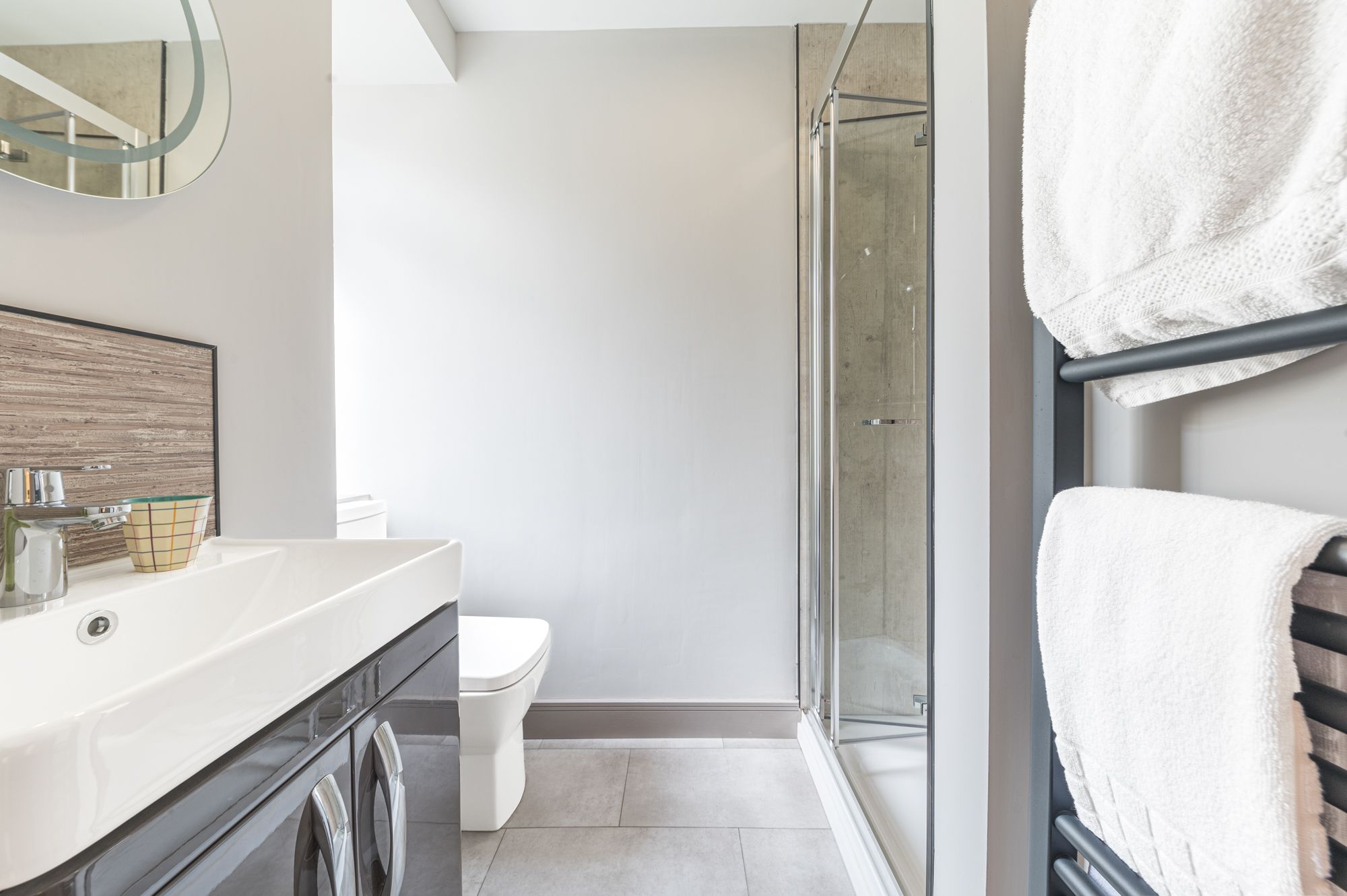 The family bathroom comprises a large walk in shower, WC, hand sink and heated towel rail
