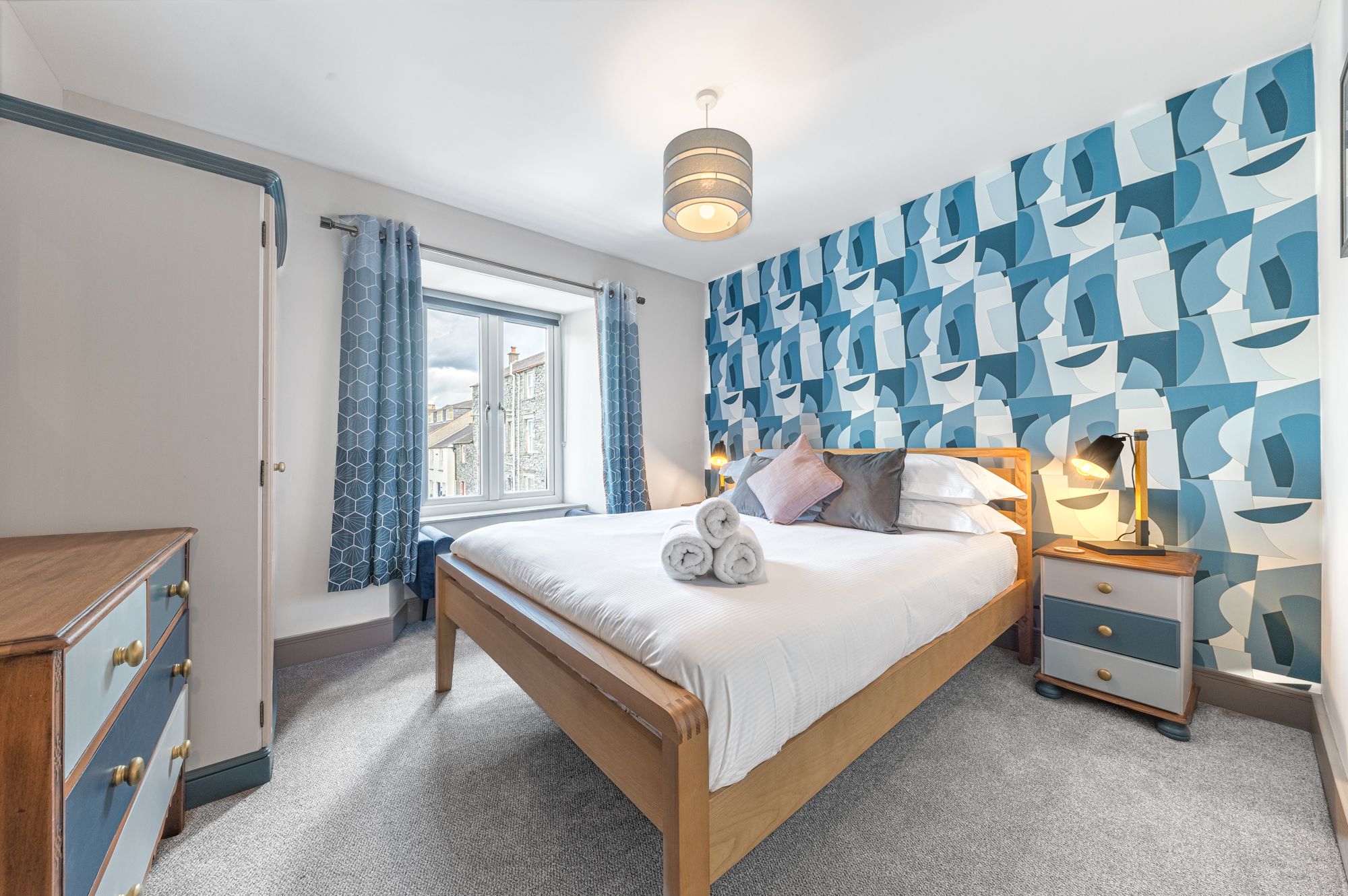 The master bedroom is furnished with a king sized bed, wardrobe, chest of drawers and bedside tables