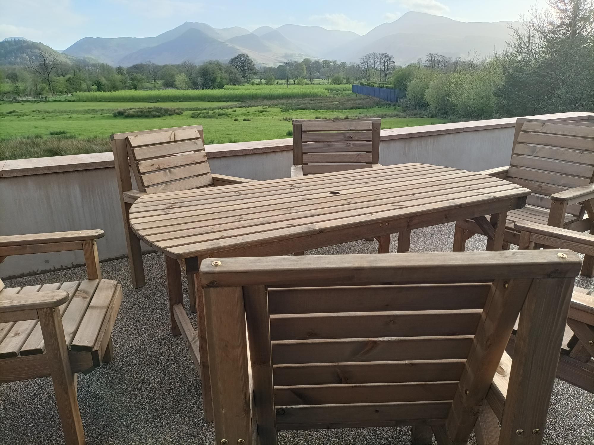 An outdoor dining area on the terrace, accessed from the living room through patio doors