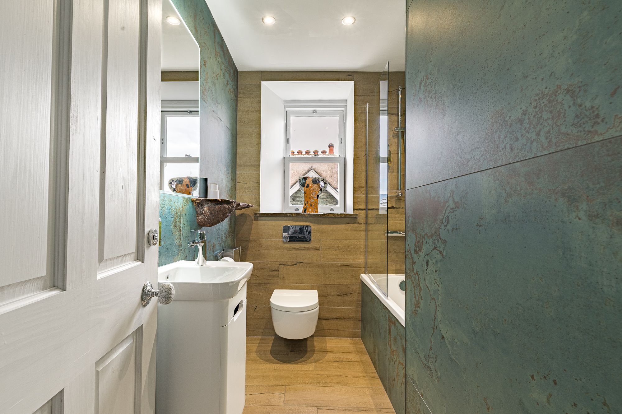 The ensuite to the fourth bedroom comprises bath with overhead shower, WC, hand sink and heated towel rail