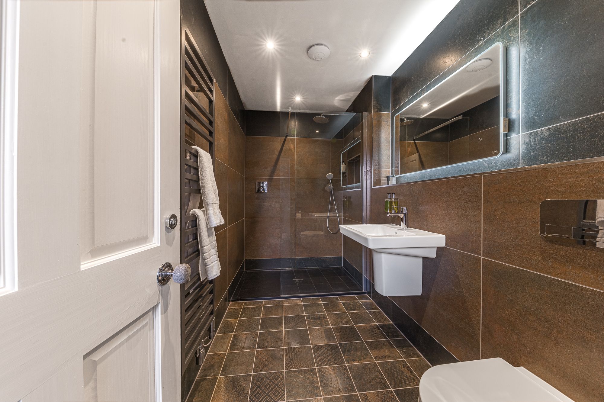The ensuite to the twin room comprises large walk in shower, WC, hand sink and heated towel rail