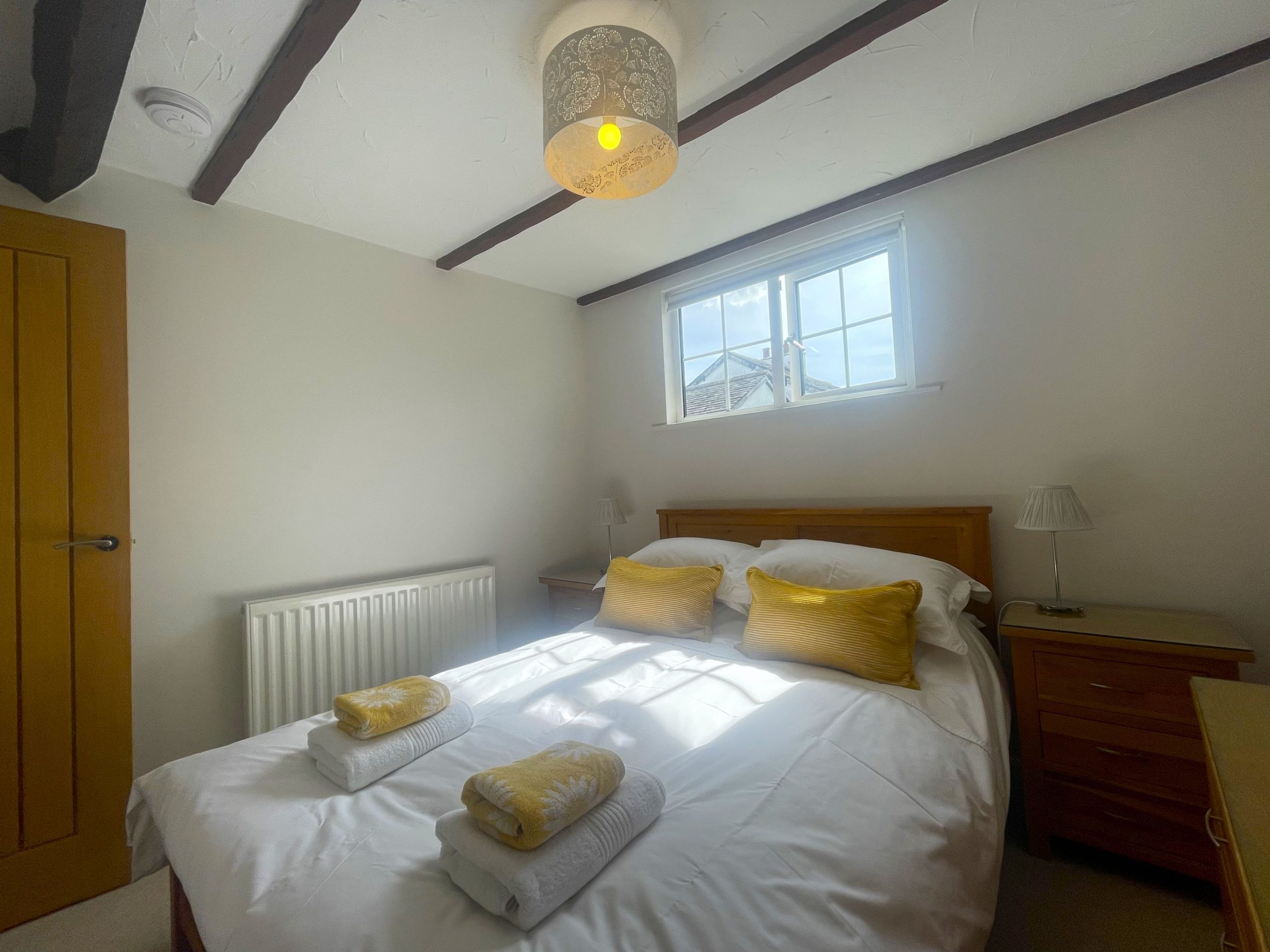 The master bedroom is furnished with a double bed, drawers and features a walk in wardrobe