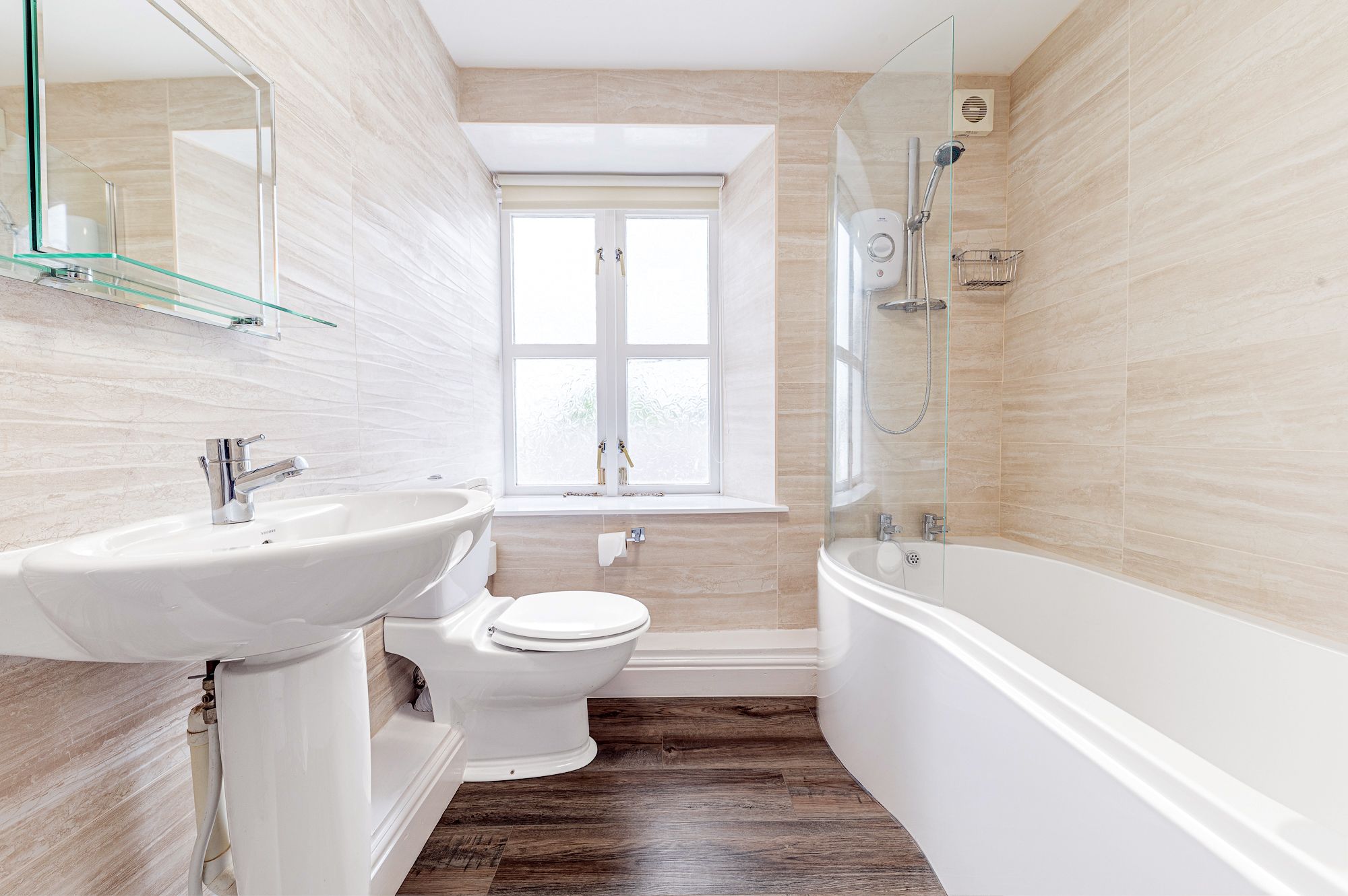 The family bathroom comprises bath with overhead shower, WC and hand basin