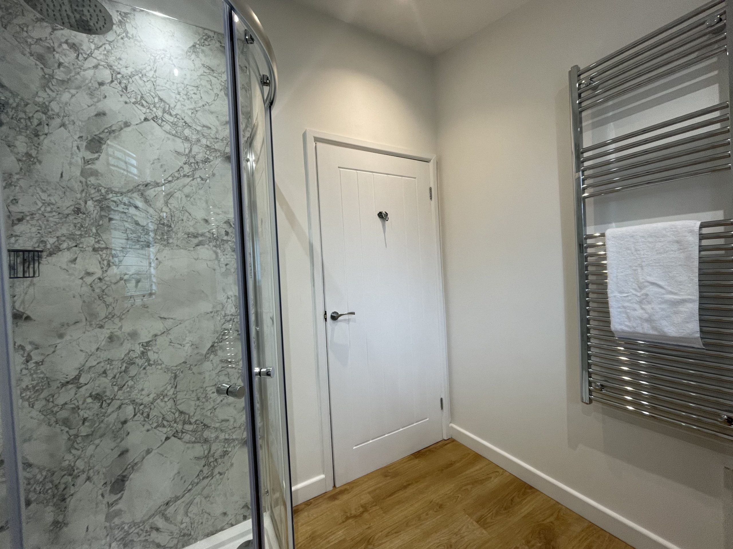 Second bathroom with waterfall shower and heated towel rail